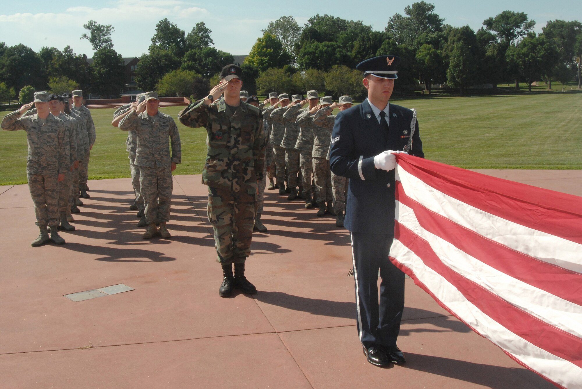 OFFUTT AIR FORCE BASE, Neb.- Airman 1st Class Jeffery Hunsberger, an Honor Guard member from the 1st Aircraft Maintenence Unit, folds the flag as Airmen from the Air Force Weather Agency and 55th Security Forces Squadron salute during the retreat ceremony signaling the end of the duty day at the Offutt Parade Grounds Aug 6. US Air Force photo by D.P. Heard
