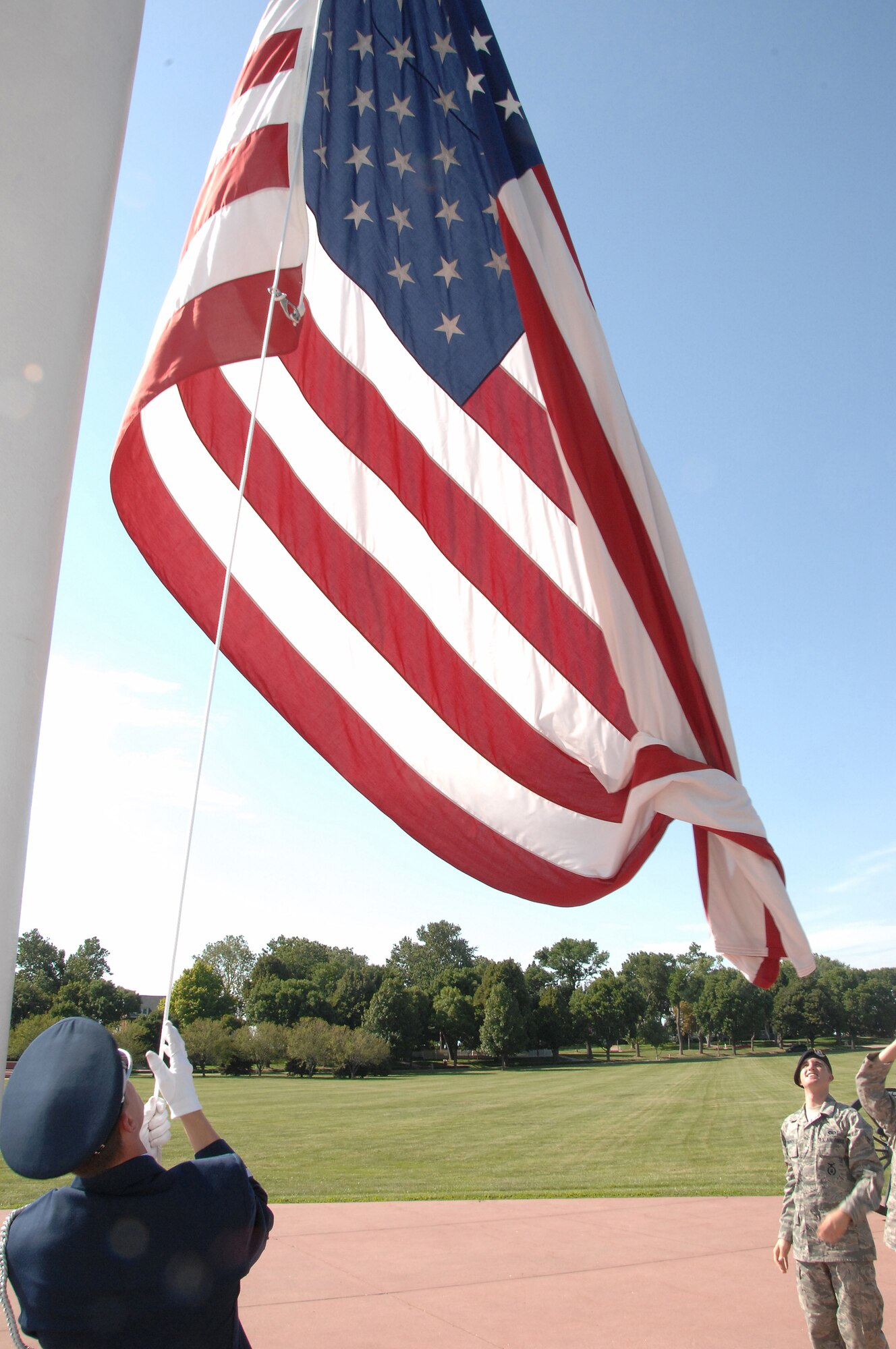OFFUTT AIR FORCE BASE, Neb.- Airman 1st Class Jeffrey Hunsberger, an Honor Guard member from the 1st Aircraft Maintenance Unit, raises the flag as Airmen from the 55th Force Support Squadron watch during the retreat ceremony at the Offutt Parade Grounds Aug. 6.
U.S. Air Force Photo by D.P. Heard

