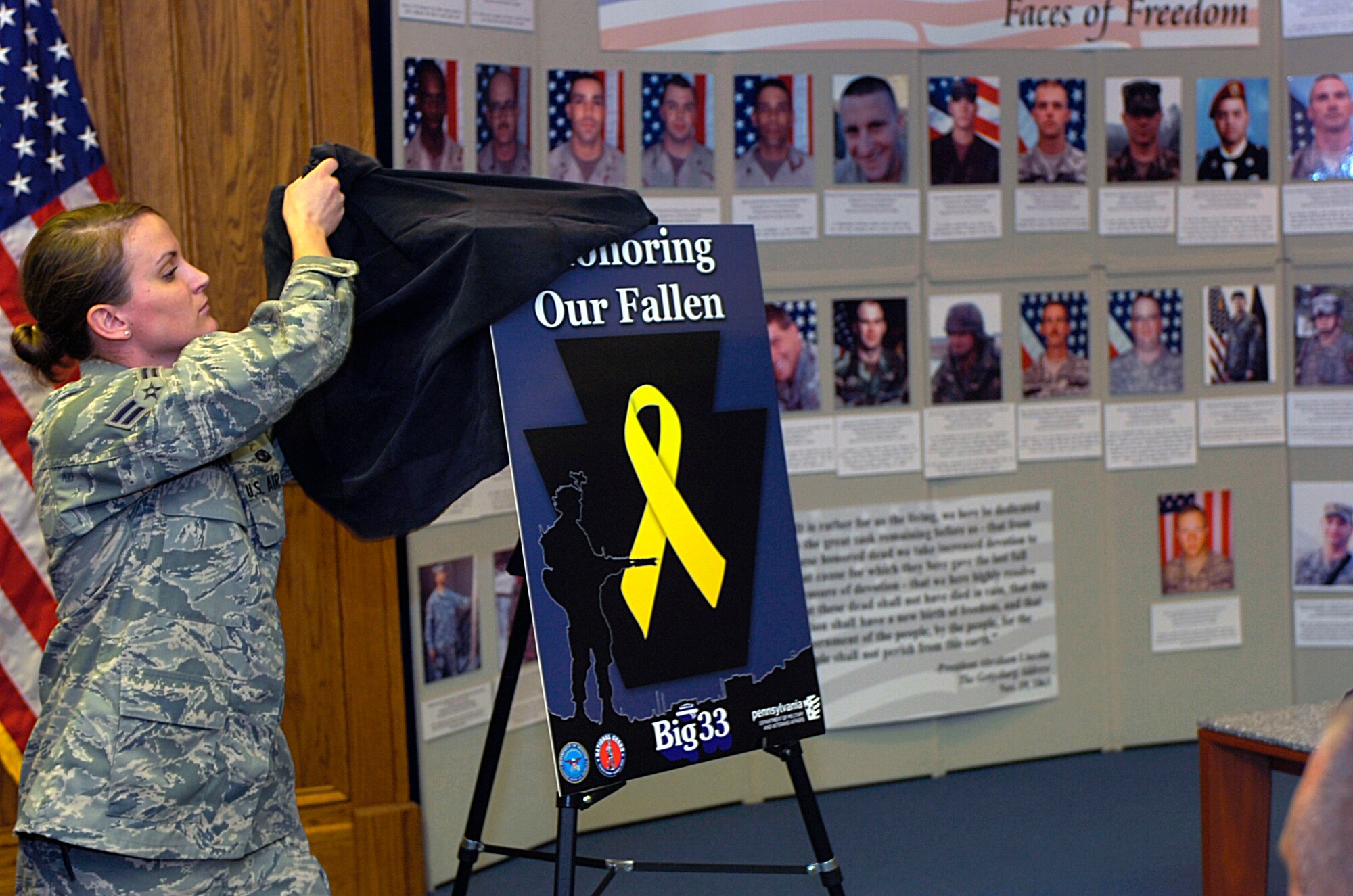 Airman 1st Class Claire Behney, a public affairs specialist for the 193rd Special Operations Wing, Middletown, Pa., unveils the design for a helmet sticker to be worn by players of the Big 33 Classic in honor of the 34 fallen Soldiers from the Pennsylvania National Guard who lost their lives during the wars in Iraq and Afghanistan.  Photo by Emily Phillippy.