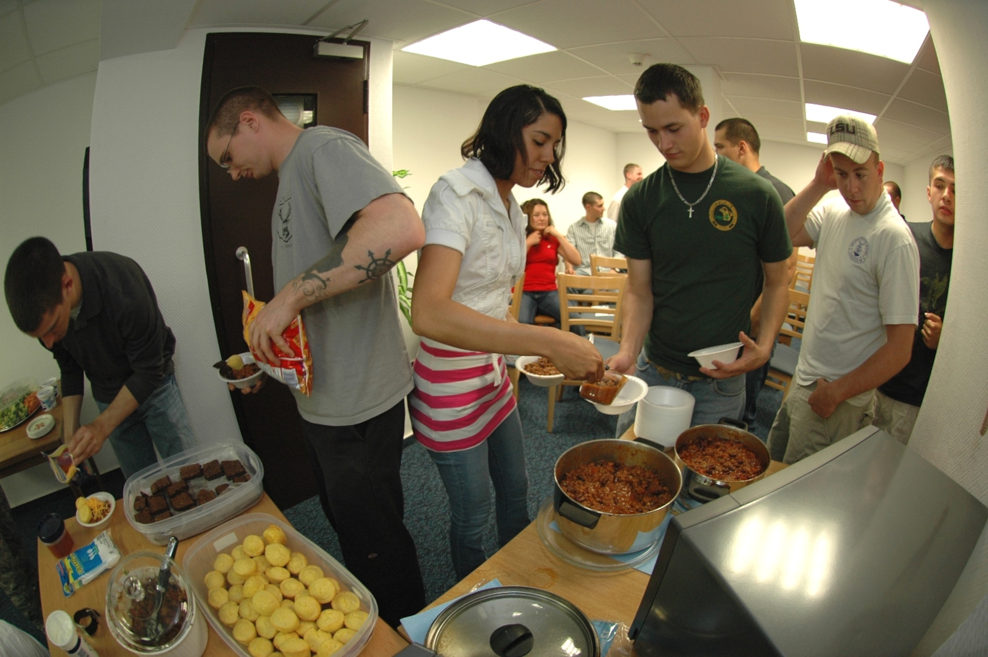 KAPAUN AIR STATION, Germany—Airmen from the 569th U.S. Forces Police Squadron prepare to eat chili, cornbread, and brownies prepared by Master Sgt. James Fuller, senior enlisted aide to the U.S. Air Forces in Europe commander, during a microwave cooking demonstration. Sponsored by the USAFE command chief’s office, Sergeant Fuller did the demo to help 569th USFPS dorm residents, who have no kitchen facilities, prepare wholesome meals in the microwave. (U.S. Air Force photo by Master Sgt. Corey Clements)