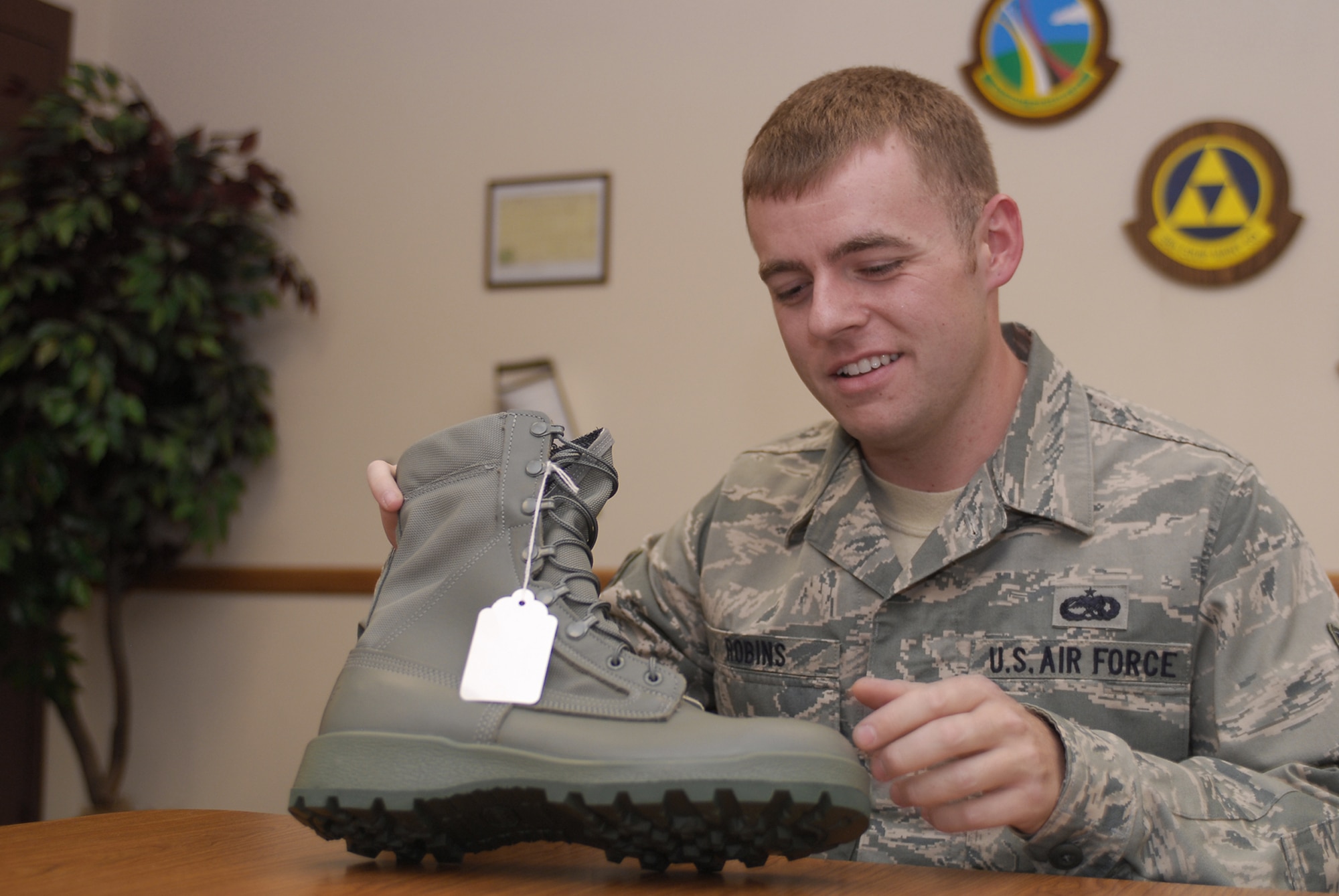 Staff Sgt. William Robins gets an idea of what he will be wearing for a 45-day test as he examines the prototype stain-resistant boot June 10 at Luke Air Force Base, Ariz. Two hundred Airmen will wear test the boot. The prototype selected will be low-maintenance and resistant to staining from harsh chemicals, oils, and fuels. Sergeant Robins is with the 56th Equipment Maintenance Squadron. (U.S. Air Force photo) 
