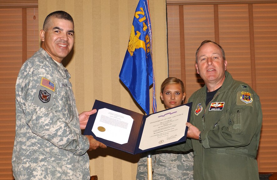 Army Maj. Gen. Hugo E. Salazar (left), the Adjutant General and commanding general of the Arizona National Guard, presents the Air Force Outstanding Unit Award citation to Col. Gregg Davies, 214th Reconnaissance Group commander. Airman First Class Samantha Field, the most junior member of the unit, served as the guideon bearer. (Air National Guard photos by Staff Sgt. Sarah Elliott)