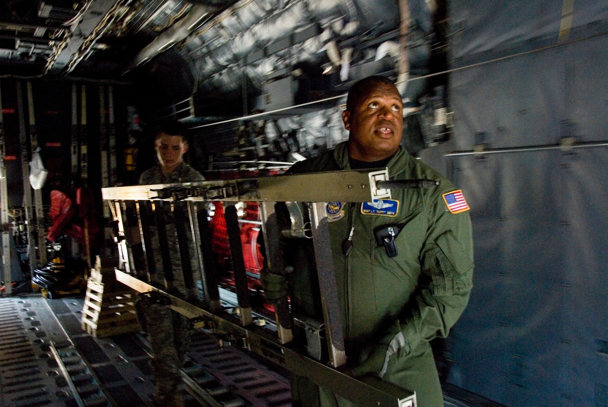 Master Sgt. L.T. “Peppy” Smith, a flight examiner for the 167th Aeromedical Evacuation Squadron, and Airmen Joseph Robert carry a ladder through a C-130 aircraft during an egress training session at the 167th Airlift Wing, West Virginia Air National Guard. The 167th AW secured the C-130, which was headed to the “bone yard” at Davis-Monthan Air Force Base, and will convert it to a training simulator for the base. (U.S. Air Force photo by Master Sgt Emily Beightol-Deyerle)