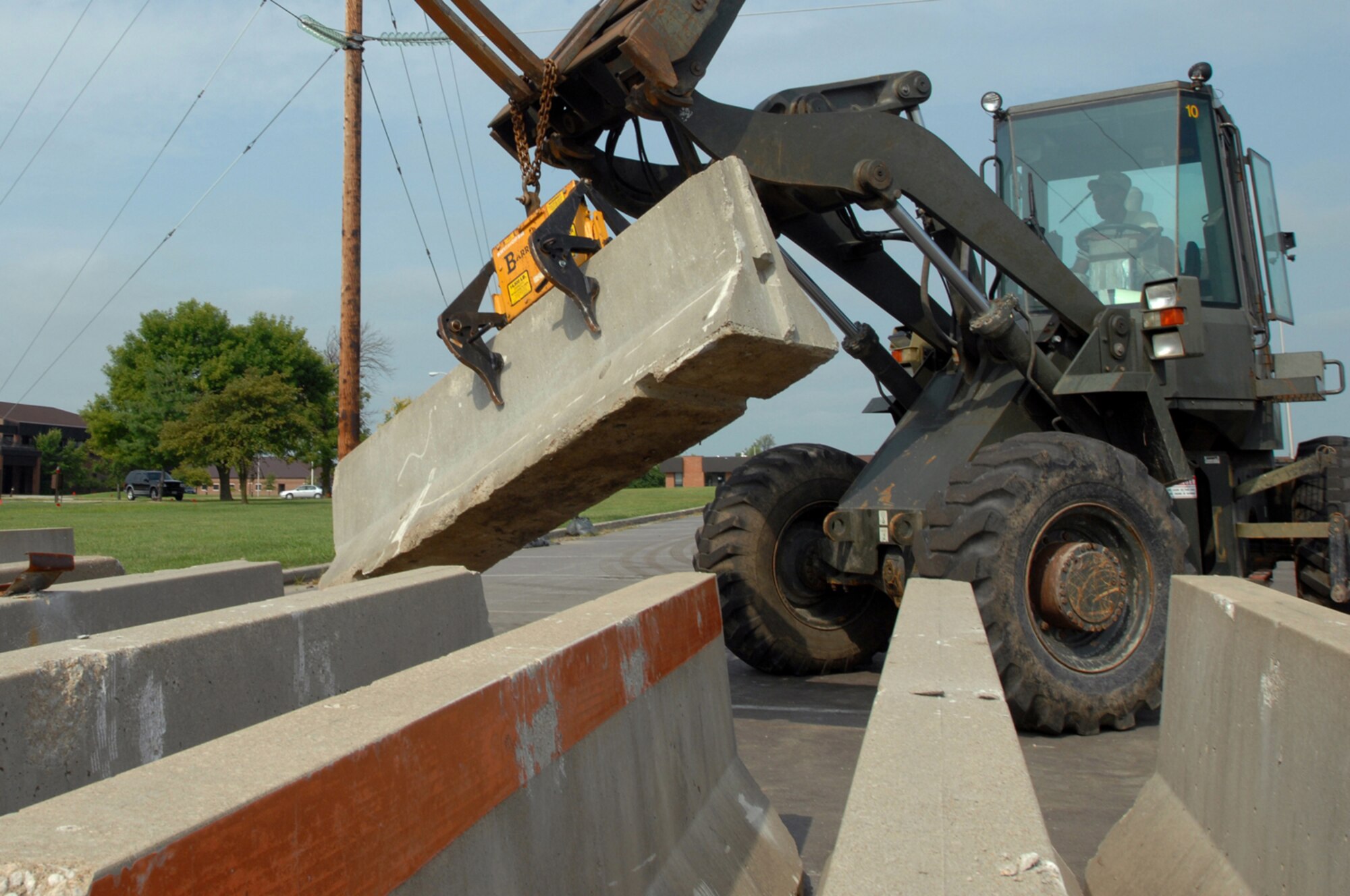 WHITEMAN AIR FORCE BASE, Mo. - Airman 1st Class Phillip William, 509th Civil Engineer Squadron, puts concrete barriers in place Aug. 5. The barriers were placed around the 509th Bomb Wing Headquarters building as a part of a force protection scenario during a weeklong Nuclear Operational Readiness Exercise. (U.S. Air Force photo/Senior Airman Kenny Holston)