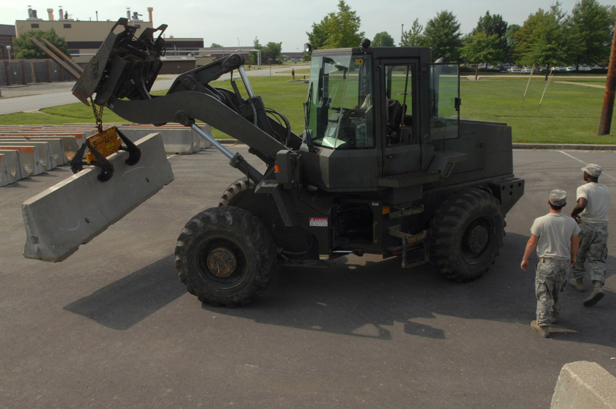 WHITEMAN AIR FORCE BASE, Mo. - Members of the 509th Civil Engineer Squadron work together to unload concrete barriers from a truck, Aug. 5. The barriers were placed around the 509th Bomb Wing Headquarters building as a part of a force protection scenario during a weeklong Nuclear Operational Readiness Exercise. (U.S. Air Force photo/Senior Airman Kenny Holston)