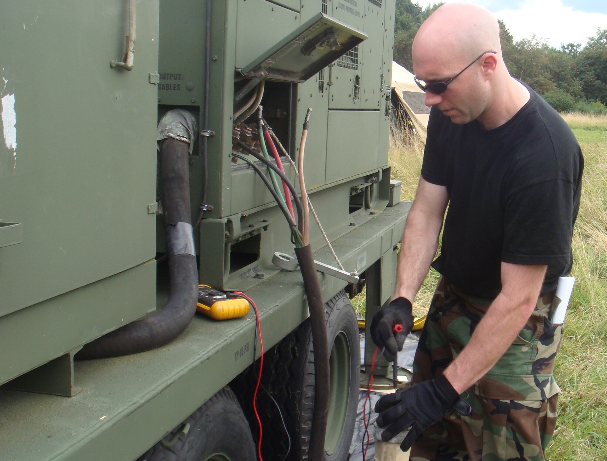 SPANGDAHLEM AIR BASE, Germany -- Staff Sgt. Matthew West, 606th Air Control Squadron power production craftsman, tests a power cable on a tactical quiet generator Aug. 3 during a combat readiness training exercise near Gerolstein, Germany. The purpose of the class is to show squadron members how to defend a deployed site without outside support, building on the 606th ACS mission to be self-sufficient. (U.S. Air Force photo/Staff Sgt. Daniel Heise)