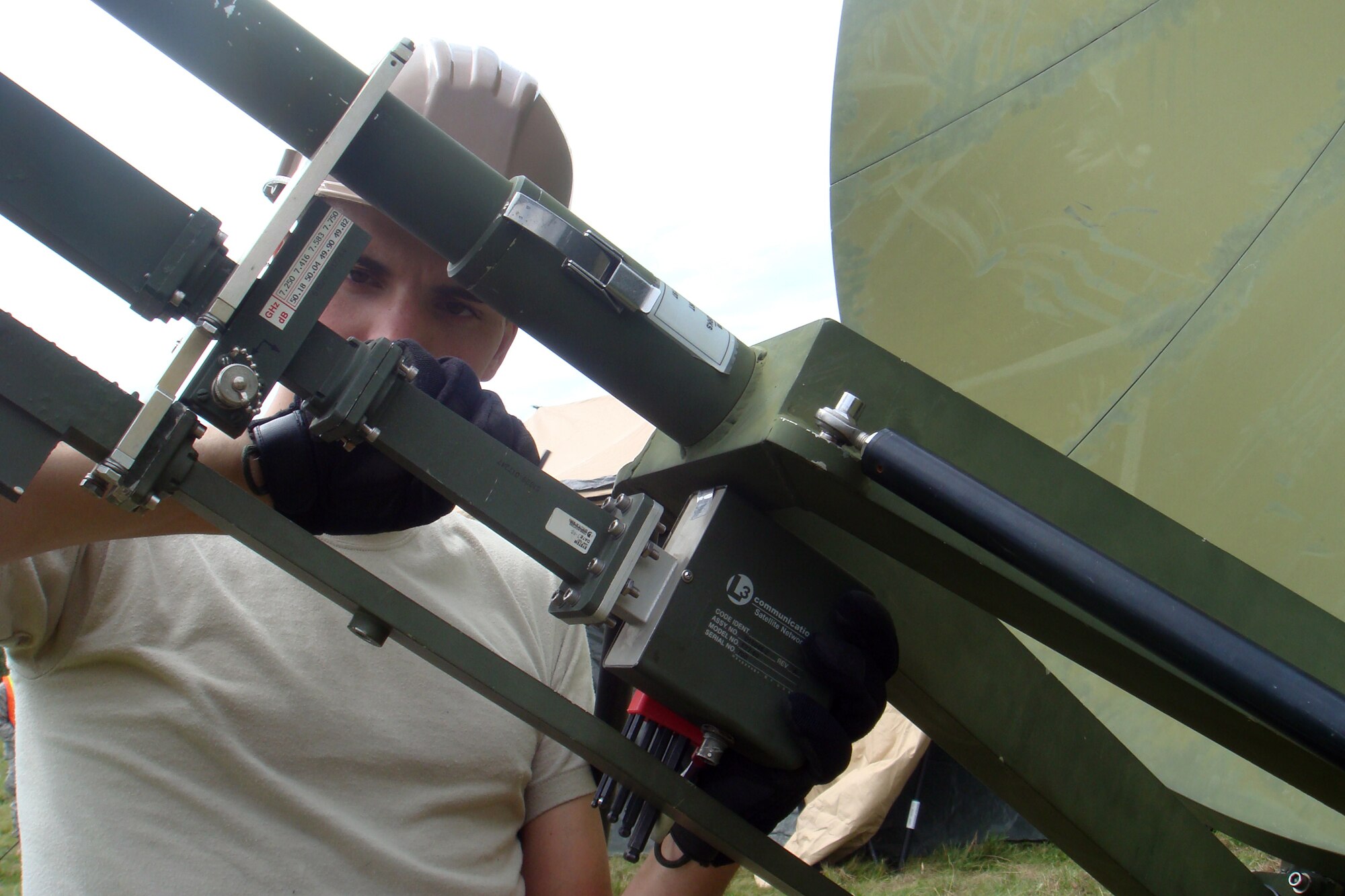 SPANGDAHLEM AIR BASE, Germany -- Senior Airman Thaddeus Kloss, 606th Air Control Squadron satellite, wideband and telemetry systems journeyman, attaches a low-noise amplifier to a satellite antenna Aug. 3 during a combat readiness training exercise. near Gerolstein, Germany. The Aug. 3-7 training exercise was part of a two-week Combat Readiness Training class that taught squadron members how to defend a deployed site without outside support. (U.S. Air Force photo/Staff Sgt. Daniel Heise)