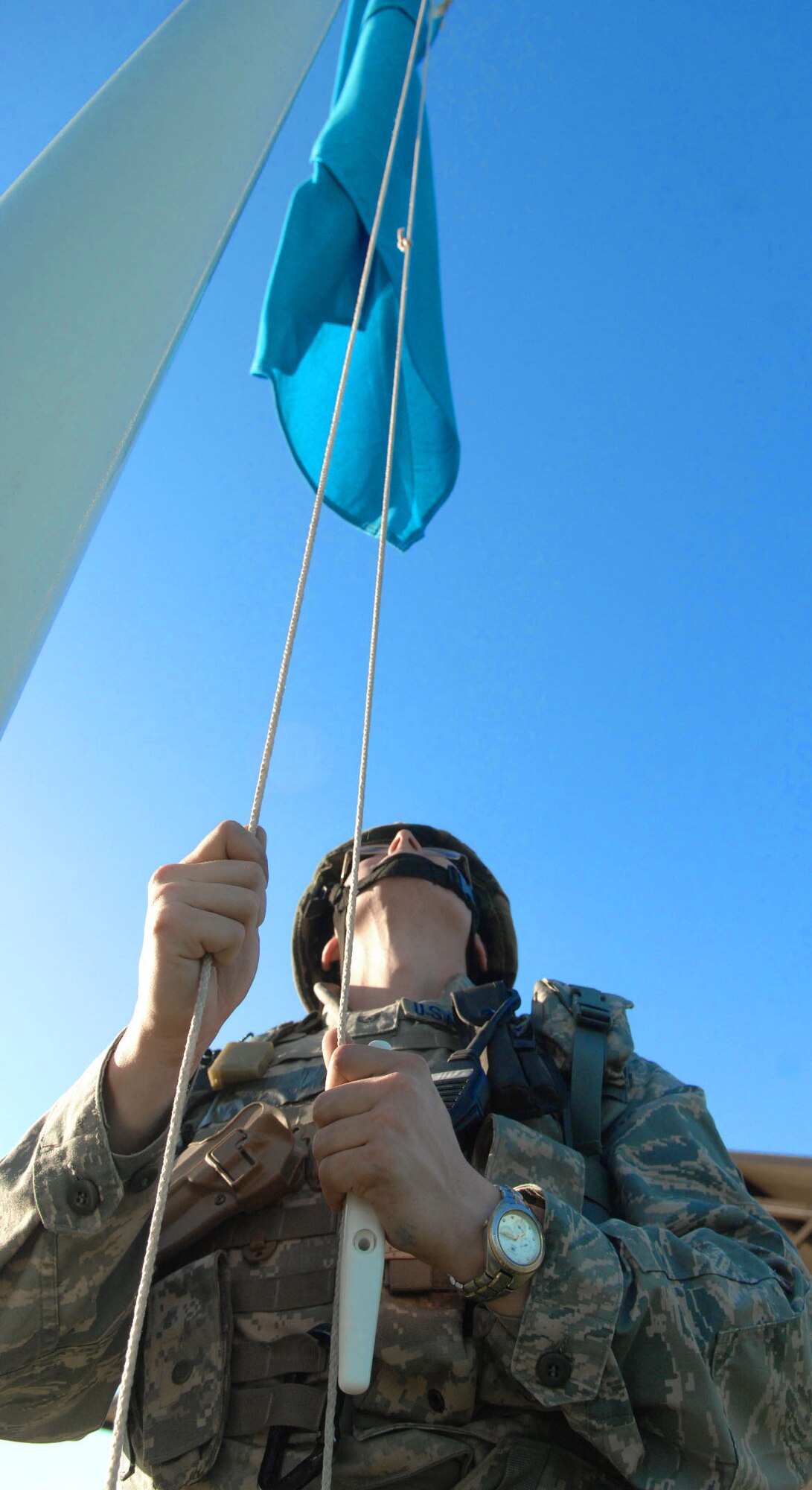 SPANGDAHLEM AIR BASE, Germany -- Staff Sgt. Joseph Null, 52nd Security Forces Squadron, raises a U.S. Air Forces in Europe communication flag at the front gate Aug. 4 during a base-wide exercise in preparation for a NATO Tactical Evaluation scheduled for 2010. The flag was raised as part of a force protection measure. USAFE headquarters periodically orders colored flags raised to measure base response times. (U.S. Air Force photo /Airman 1st Class Nick Wilson)