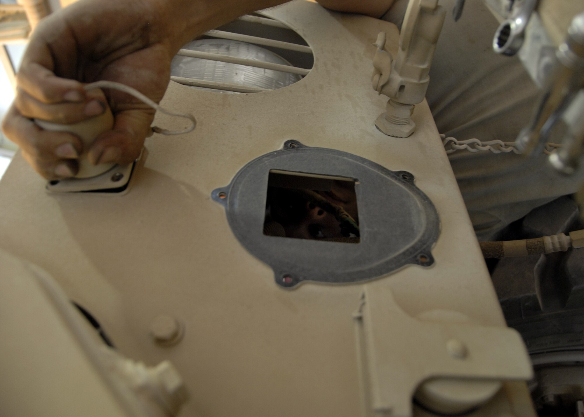 Airman Lucci removes a slave cable receptacle from a Mine Resistant Ambush Protected vehicle at Kandahar Airfield, Afghanistan Aug. 8. The slave cable receptacle is used to jump start an MRAP if the batteries die. Airman Lucci is deployed here from McGuire AFB, New Jersey in support of operation ENDURING FREEDOM as a vehicle maintenance technician and hails from Colorado Springs, Colo. (U.S. Air Force photo/Senior Airman Timothy Taylor)

