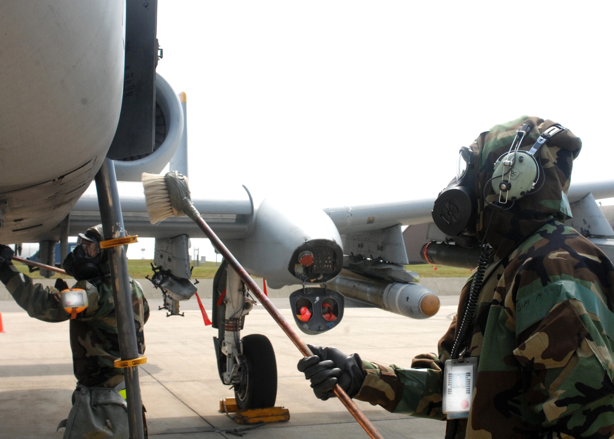 SPANGDAHLEM AIR BASE, Germany -- Senior Airman Bryan Craver and Tech. Sgt. Matthew Coffman, 52nd Aircraft Maintenance Squadron, decontaminate an A-10 Thunderbolt II outside hangars 1 and 2 Aug. 6 during the 52nd Fighter Wing’s Phase II exercise. Airmen were required to decontaminate the jet while in mission oriented protective posture 4 while being evaluated during an inject by the exercise evaluation team in preparation for the upcoming NATO Tactical Evaluation in June 2010. (U.S. Air Force photo/Senior Airman Jenifer H. Calhoun)