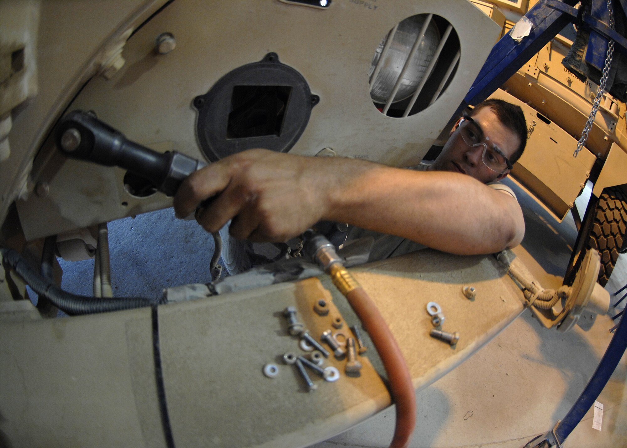 Airman Lucci operates a pneumatic socket wrench to loosen a dented fender on a Mine Resistant Ambush Protected vehicle at Kandahar Airfield, Afghanistan, Aug. 8. Airman Lucci’s fifteen man shop manages and repairs more than $80 million in assets base-wide. Airman Lucci is deployed here from McGuire AFB, New Jersey in support of operation ENDURING FREEDOM as a vehicle maintenance technician and hails from Colorado Springs, Colo. (U.S. Air Force photo/Senior Airman Timothy Taylor)

