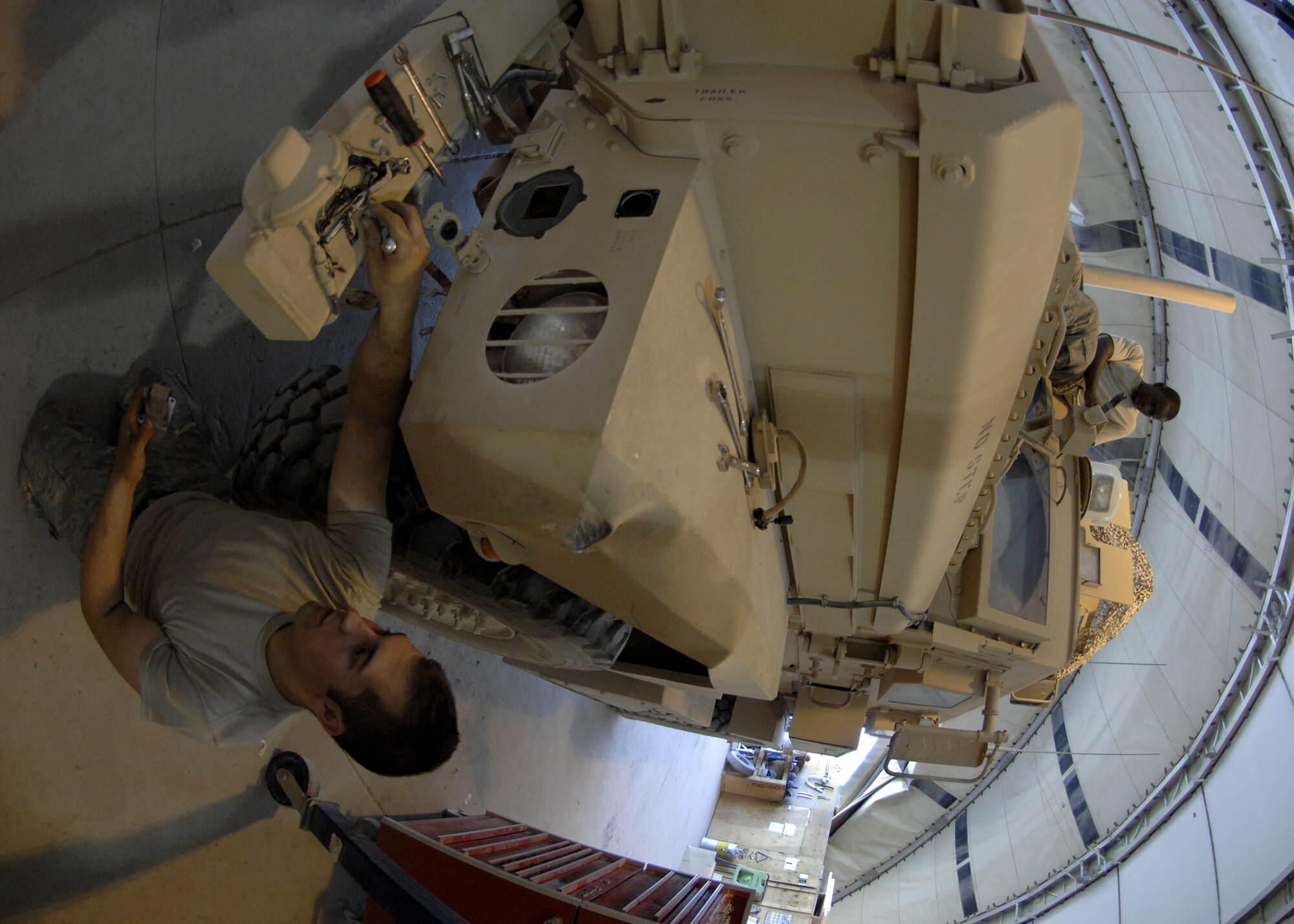 Senior Airman Jared Lucci (bottom) and Senior Airman Rennison Abraham repair a Mine Resistant Ambush Protected vehicle after striking a stationary object at Kandahar Airfield, Afghanistan Aug. 8. MRAPs are designed to withstand Improvised Explosive Device attacks keeping occupants and equipment inside safe. (U.S. Air Force photo/Senior Airman Timothy Taylor)
