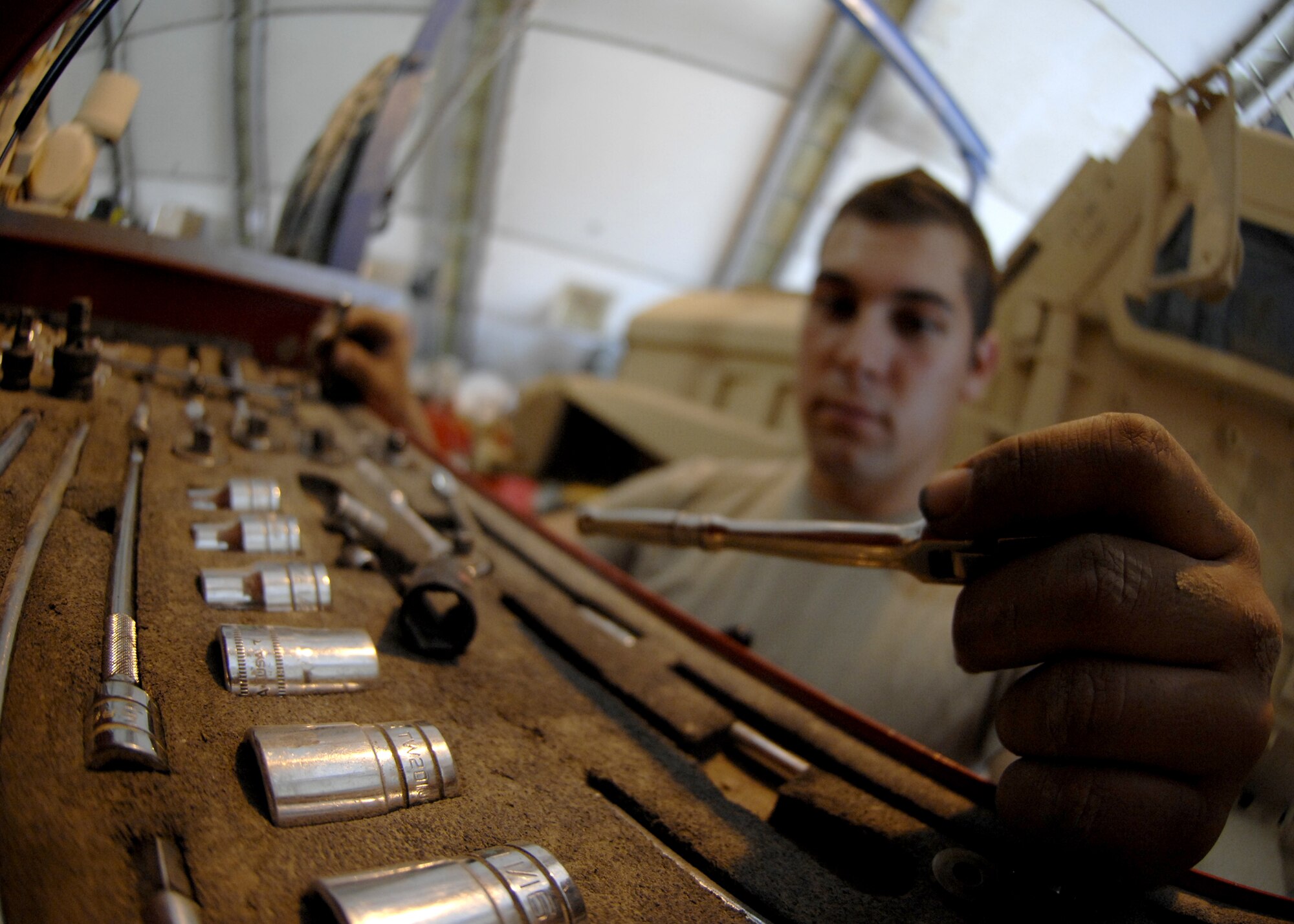 KANDAHAR AIR FIELD, Afghanistan -- Senior Airman Jared Lucci selects the proper tools to repair a damaged Mine Resistant Ambush Protected vehicle at Kandahar Airfield, Afghanistan, Aug. 8, 2009. Maintenance Airmen are trained to use dozens of tools to complete the job at hand. Airman Lucci is deployed here from McGuire Air Force Base, N.J. in support of Operation ENDURING FREEDOM as a vehicle maintenance technician and hails from Colorado Springs, Colo. (U.S. Air Force photo/Senior Airman Timothy Taylor/ Released)
