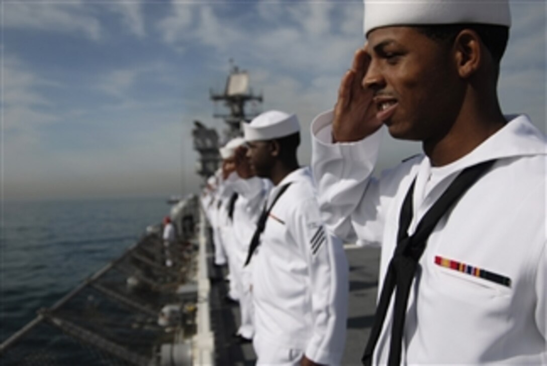 U.S. Navy sailors aboard the USS Makin Island (LHD 8) render honors while manning the rails as the ship pulls into Rio de Janeiro, Brazil, on Aug. 3, 2009.  The Makin Island departed Pascagoula, Miss., on July 10 and is circumnavigating South America, via the Strait of Magellan, to its new homeport of San Diego.  During its transit, the ship is scheduled to make port visits in Chile and Peru to support U.S. Southern Command objectives for enhanced maritime security and to share methods and training that will build on U.S. and partner nations' interoperability and relationships.  The Makin Island is the Navy's last Wasp-class amphibious assault ship to be built and is scheduled to be commissioned in October.  