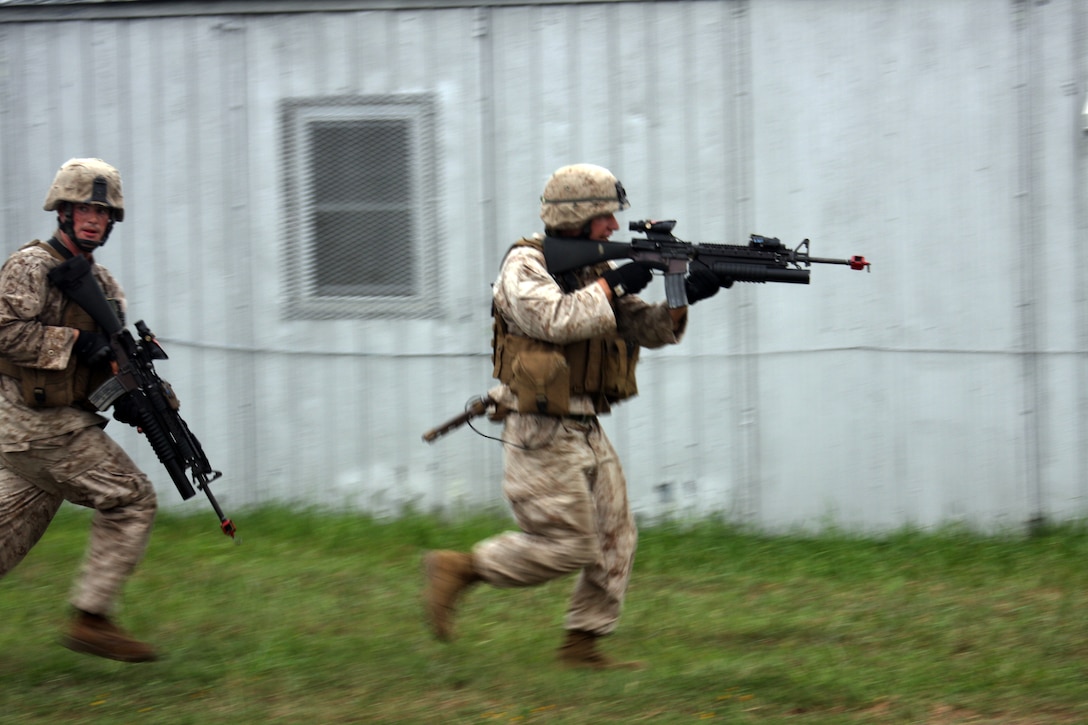 Marines with Bravo Company, Battalion Landing Team 1/9 sprint across an open area to the next building in need of securing. In this scenario Marines trained to sieze an enemy checkpoint during the motorized raid of Cooke Camp aboard U.S. Army Base Fort A.P. Hill, Va. Aug 12.  (U.S. Marine Corps Photo by LCpl. David J. Beall)