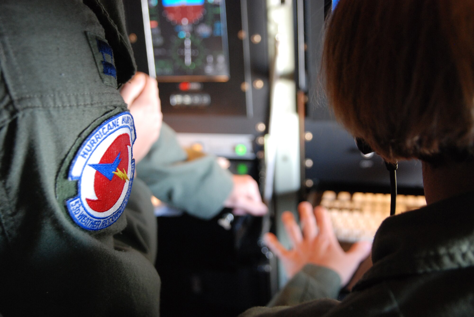 HICKAM AIR FORCE BASE -- Capts. Ellen Bundy and Tina Smith, 53rd Weather Reconnaissance Squadron meteorologists, discuss data obtained during a 10-hour mission through tropical storm Felicia Aug. 7. The unit, also known as the Hurricane Hunters, operate the WC-130J aircraft for weather reconnaissance into some of the most violent storms on Earth -- tropical cyclones. Hurricane Felicia reached peak strength as a Category 4 storm with sustained winds of more than 145 mph. The 53rd WRS is a one-of-a-kind U.S. Air Force Reserve unit and the only Department of Defense organization still flying into tropical storms and hurricanes since 1944. Their fleet of 10 Lockheed-Martin WC-130J aircraft and crews are part of the 403rd Wing, based at Keesler Air Force Base, Biloxi, Miss. (U.S. Air Force photo/Staff Sgt. Mike Meares)