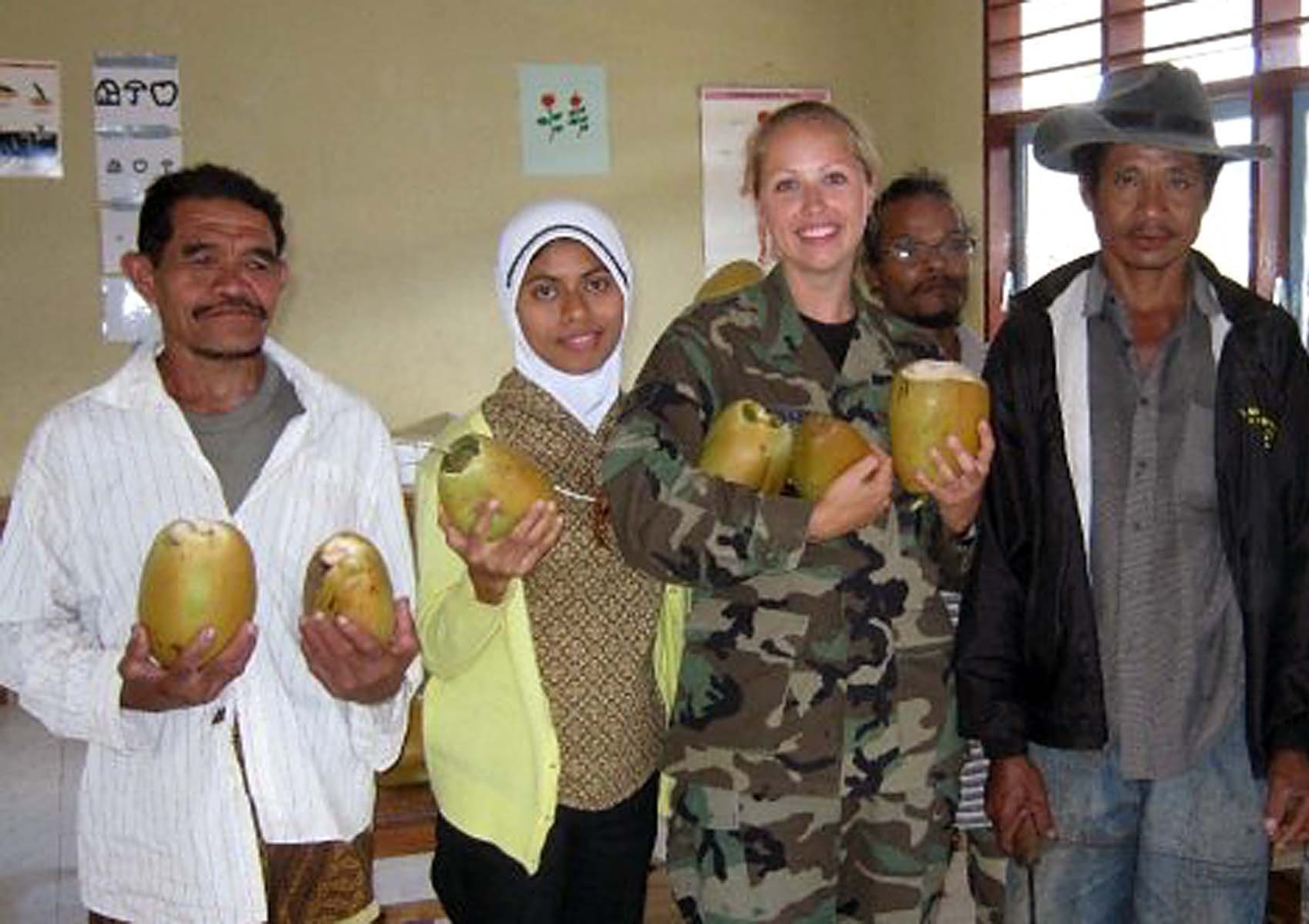 Staff Sgt. Carrie Conley, 446th Aerospace Medicine Squadron, McChord Air Force Base, Wash., recieves coconuts from a group of locals as a sign of thanks after giving candy to some Timorese children candy while on deployment to West Timor in support of Pacific Angel and its continuing humanitarian mission.  (Courtesy photo)