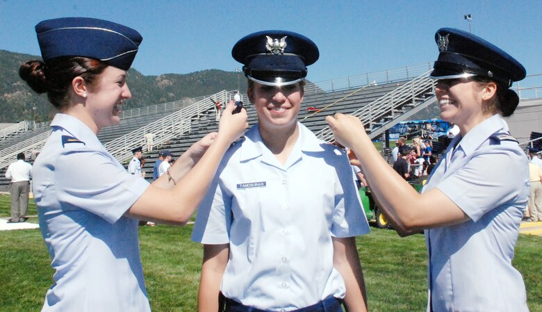 Second Lt. Amanda Tamosuinas (left) and Cadet 2nd Class Alexis Tamosuinas (right) present their sister, Cadet 4th Class Ava Tamosuinas, with her shoulder boards following the Acceptance Parade at the U.S. Air Force Academy, Colo., Aug. 4, 2009. Lieutenant Tamosuinas, a 2008 Academy graduate, is assigned to the 27th Special Operations Logistics Readiness Squadron at Cannon Air Force Base, N.M. (U.S. Air Force photo/Ann Patton)