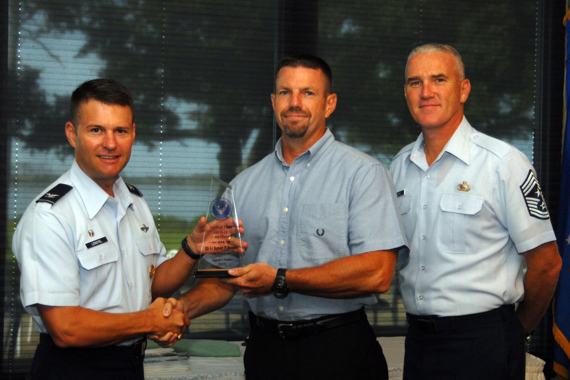 HURLBURT FIELD, FL-- Colonel Gregory Lengyel, 1st Special Operations Wing commander and 1 SOW Command Chief Master Sgt. Brooke McLean presents the Civilian of the Quarter in the GS-9 thru GS-12 category to Mr. Robert Henson from the Special Tatics Training Squadron at the Quarterly Awards Breakfast for the second quarter, 4 Aug. (U.S. Air Force photo by Staff Sgt. Orly N. Tyrell)