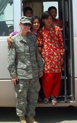 Airman 1st Class Sabrina Hibbens poses for a photograph with Afghani civilians while deployed in support of American special forces in western Afghanistan's Uruzgan and North Helmand provinces. (U.S. Air Force photo)