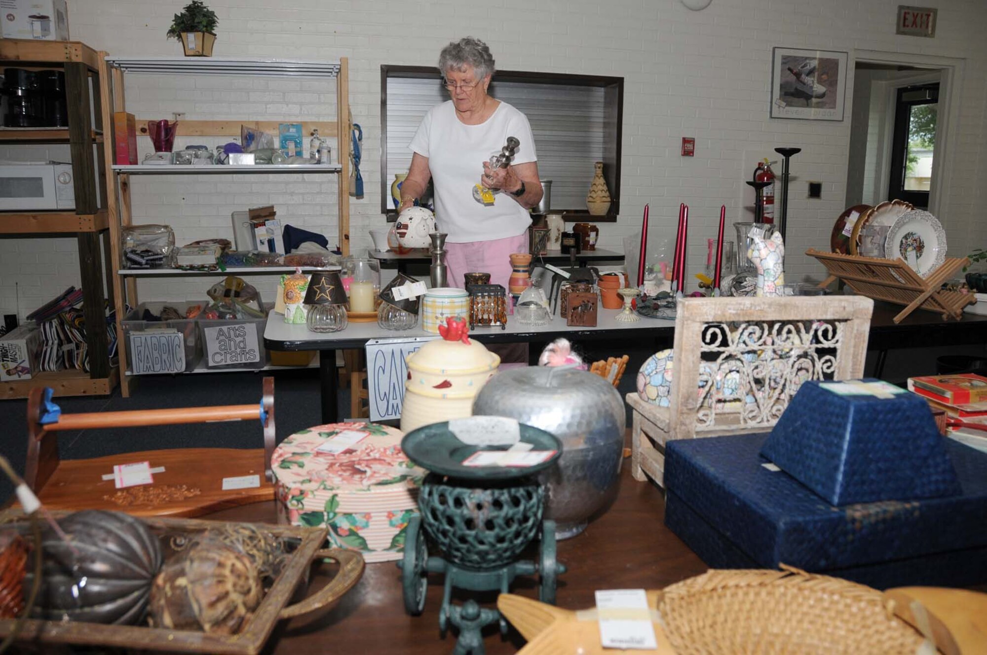 Kathy Varble, a longtime club member and thrift shop volunteer, sorts through household items.  (U.S. Air Force photo by Kemberly Groue)