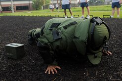 Staff Sgt. Javier Parris completes a push-up in the Explosive Ordnance Disposal bomb suit during the Commander’s Challenge Aug. 7. The Commander’s Fitness Challenge is held the first Friday of every month. During this specific event each Airman had to do 10 push-ups, sprint to an ammo box, carry the ammo box back and complete another set of 10 push-ups all while wearing the bomb suit. Sergeant Parris is a maintainer with the 1st Combat Camera Squadron. (U.S. Air Force photo/Airman 1st Class Alexandra Hoachlander)