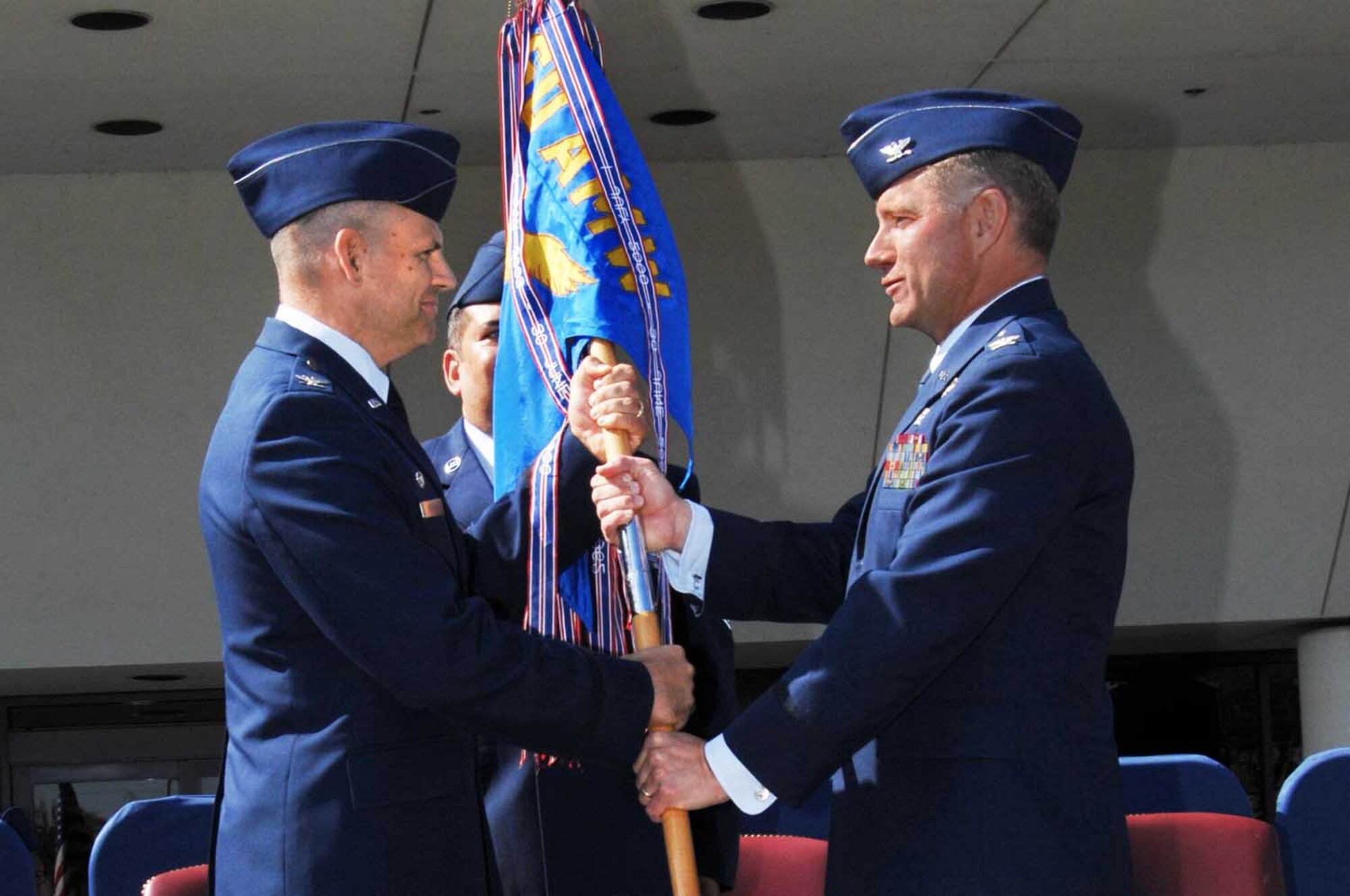 Col. James Vechery, 60th Air Mobility Wing commander, hands the 60th Medical Group guideon to Dr. (Col.) Brian Hayes, new 60th MDG commander. (U.S. Air Force photo/Nan Wylie)