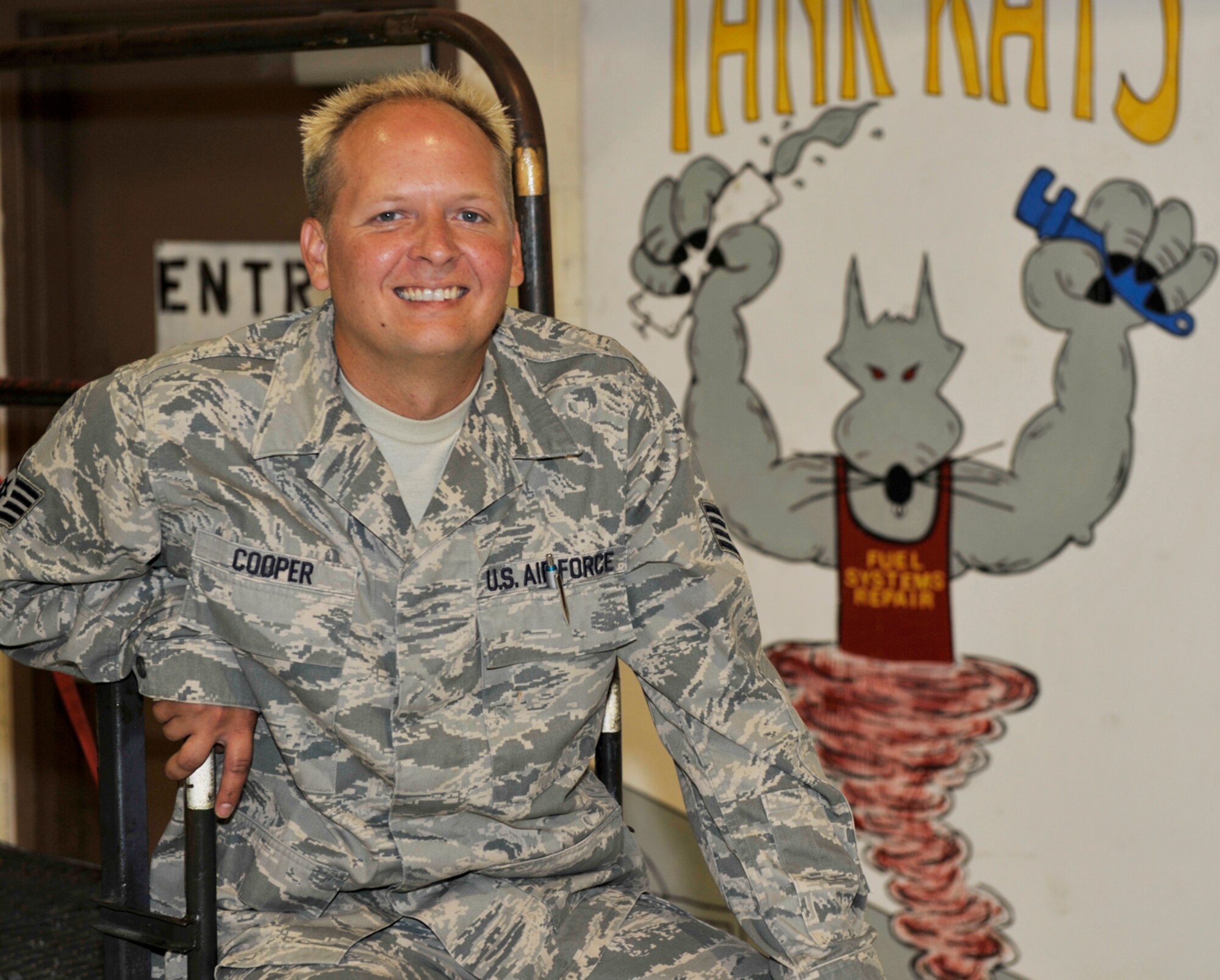 Staff Sgt. Brady Cooper is a fuels systems craftsman assigned to the 931st Aircraft Maintenance Squadron. His job includes working on KC-135 Statotanker fuel tanks from the inside. The illustration behind him refers to the "tank rat" nature of the work. (U.S. Air Force photo/Tech. Sgt. Jason Schaap)