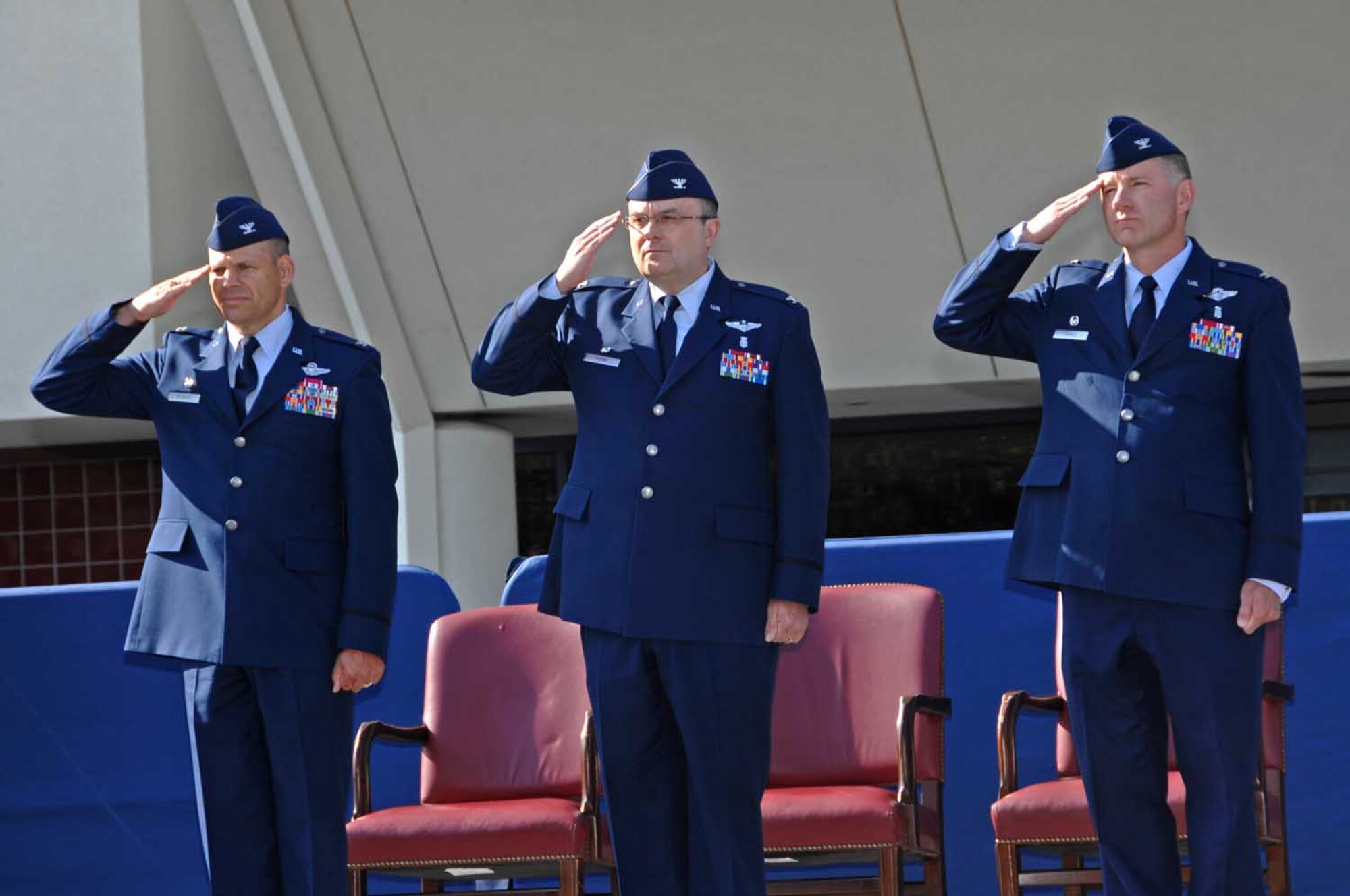 Col. James Vechery, (left,) 60th Air Mobility Wing commander, Dr. (Col.) Lee Payne, former 60th Medical Group commander and Dr. (Col.) Brian Hayes, new 60th MDG commander, salute during the 60th MDG change-of-command ceremony Aug. 7 at the David Grant USAF Medical Center. (U.S. Air Force photo/Nan Wylie)