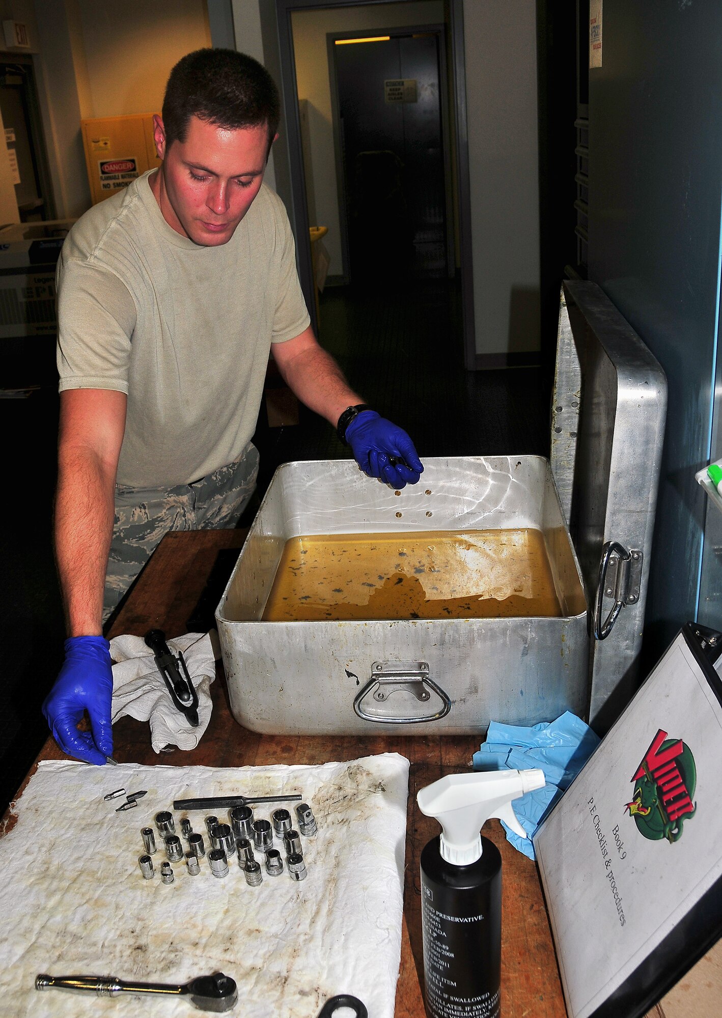 Senior Airman Brad Chambers removes tool sockets from a pan of cleaning solution during a rust removal inspection of a tool kit at the Viper support section here Aug. 12. The Viper support section performs regular derust inspections after heavy rainfall for corrosion control of tools and equipment needed to maintain Charleston AFB aircraft. Airman Chambers is a flightline support specialist with the 437th Aircraft Maintenance Squadron.
