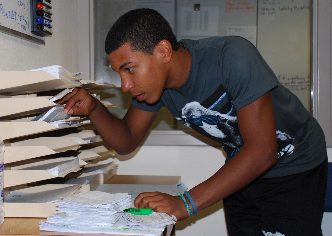 Fernando Moore, a 360th Training Squadron summer hire, files and organizes paperwork to lighten the load for his coworkers. The Summer Hire Program prepares students in high school and college for the future by allowing them to work directly with civil service employees and military members during the summer break. (U.S. Air Force photo/Krystal Everett)
