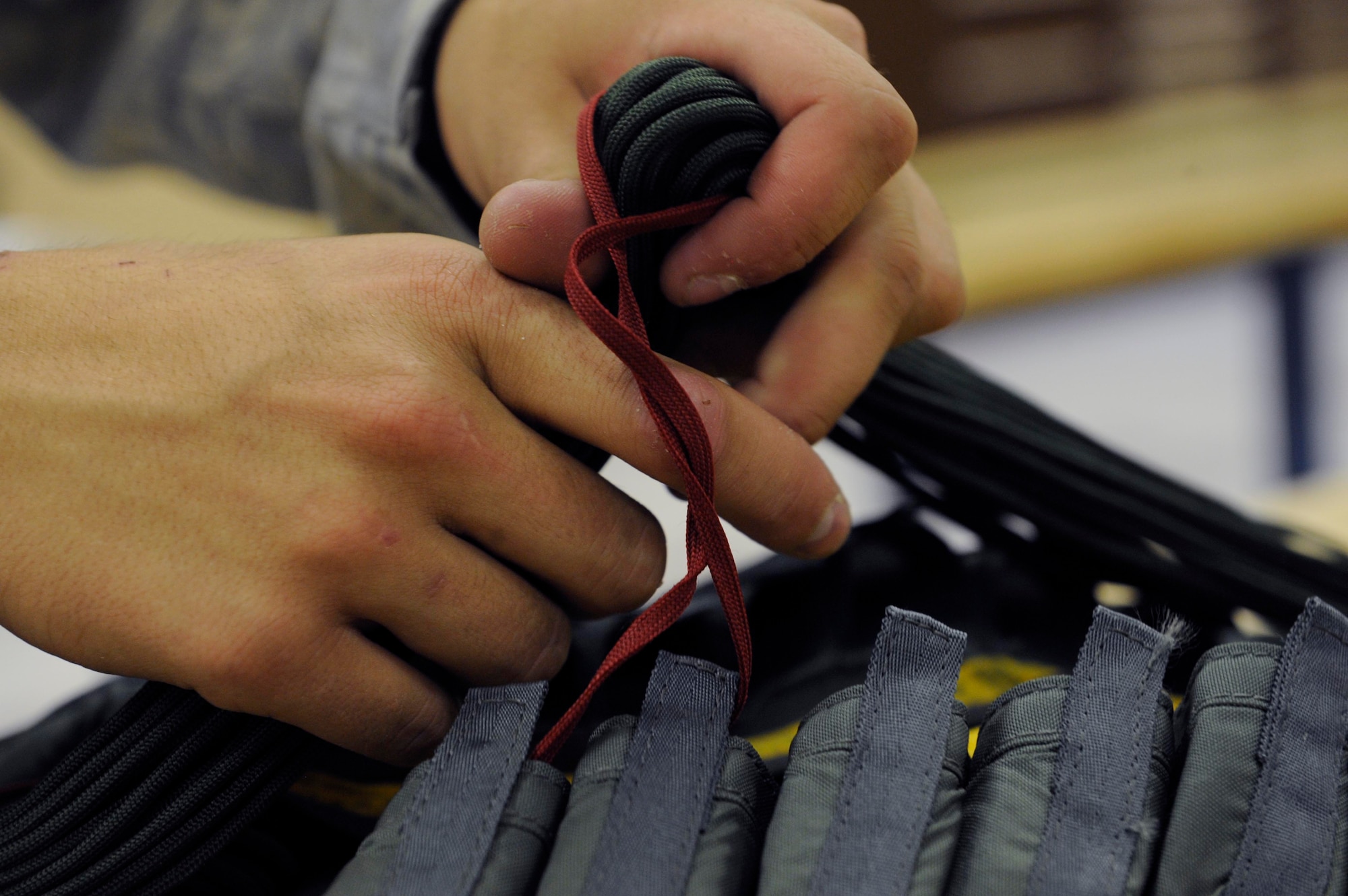 Airman 1st Class Stephen Barker, 28th Operations Support Squadron aircrew flight equipment apprentice, stows the lines of a back automatic-22 parachute here, August 10. Air crew flight equipment members inspect and pack an average of four parachutes a week to ensure safety standards are met. (U.S. Air Force photo by Airman 1st Class Corey Hook)