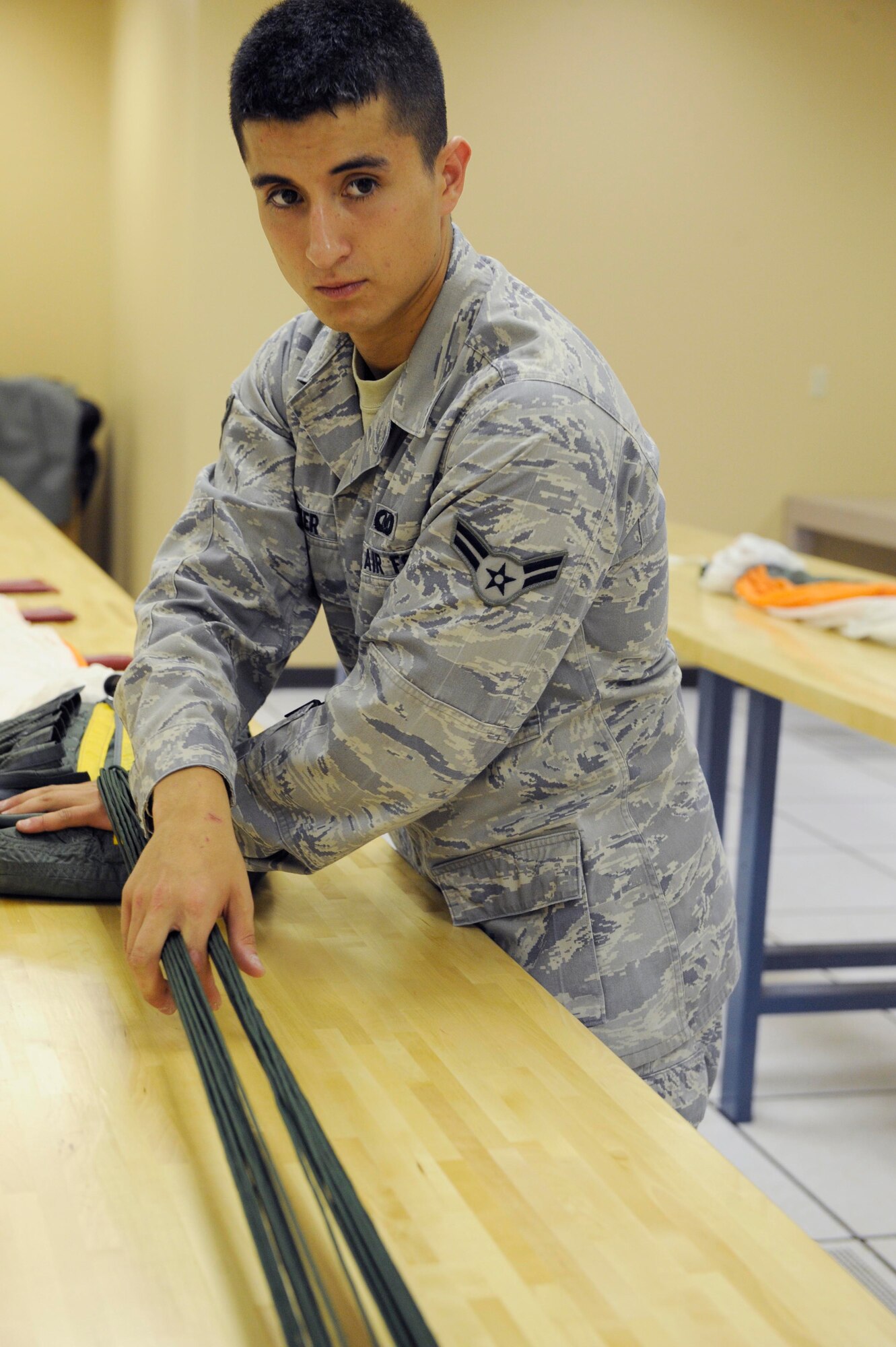 Airman 1st Class Stephen Barker, 28th Operations Support Squadron aircrew flight equipment apprentice, ensures suspension lines are separated before packing a back automatic-22 parachute here, August 10. Every inch of the parachute must be inspected before it is considered serviceable for aircrew use. (U.S. Air Force photo by Airman 1st Class Corey Hook)