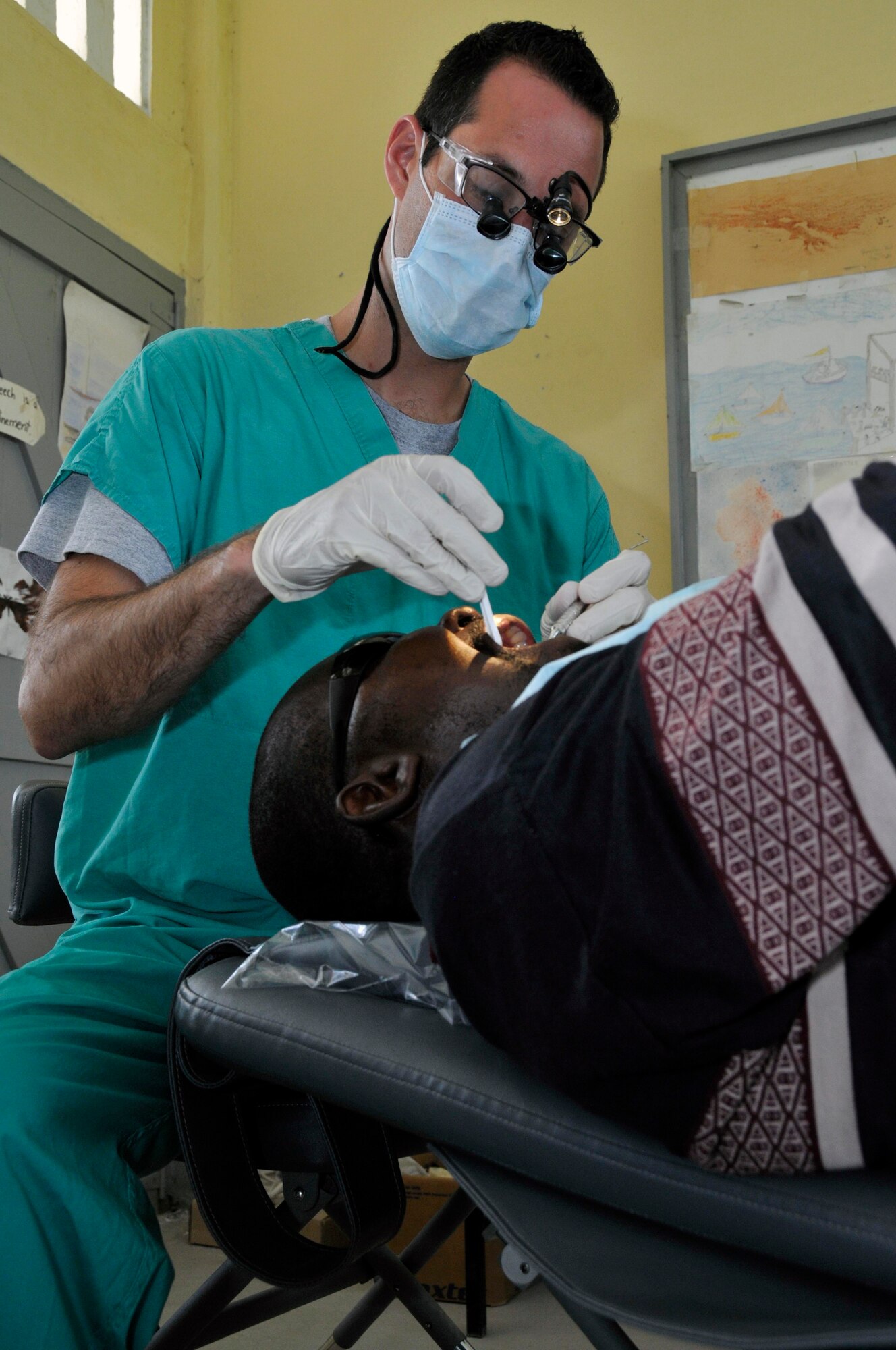 Capt. Theadore Jackson, Dentist from the 375th Dental Squadron, Scott AFB, Illinois, gives a Guyanese man a filling at the Diamond School Aug 10, 2009, in Diamond, Guyana. Providing free dental care is just one part of the New Horizons Guyana humanitarian mission. More than 650 service members are providing assistance during this mission by building medical clinics and schools and providing free medical, dental and optometry care.(U.S. Air Force photo by Airman 1st Class Perry Aston) (Released)