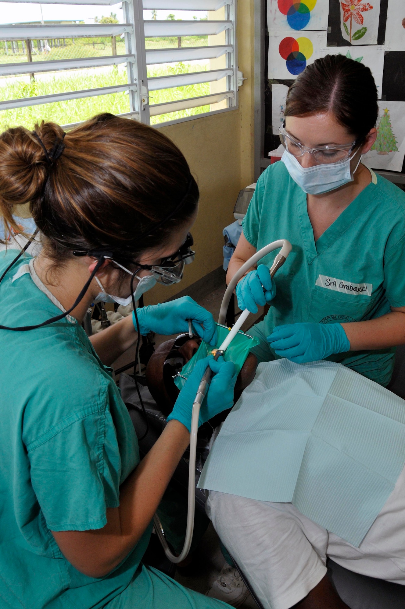 Capt. Kimberly Morio, Dentist, and Senior Airmen Brittany Grabowski, Dental Technician from the 375th Dental Squadron, Scott AFB, Illinois, gives a Guyanese man a filling at the Diamond School Aug 10, 2009, in Diamond, Guyana. The Airmen will be providing dental care to the local population for free during New Horizons Guyana, a $9 million exercise designed to strengthen ties with partner nations in Central and South America through combined quality of life improvement projects.(U.S. Air Force photo by Airman 1st Class Perry Aston) (Released)