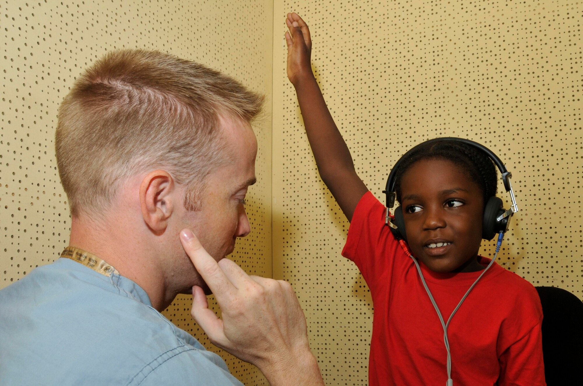 Capt. Johnny Foster, audiologist from the 59th Medical Wing at Wilford Hall, Lackland Air Force Base, Texas, ensures a Guyanese boy understands how to perform the hearing test Aug 11, 2009, at the Georgetown Public Hospital in Georgetown, Guyana. Ear, Nose, and Throat doctors deployed here wil see more than 500 patients in 8 days. (U.S. Air Force photo by Airman 1st Class Perry Aston) (Released)