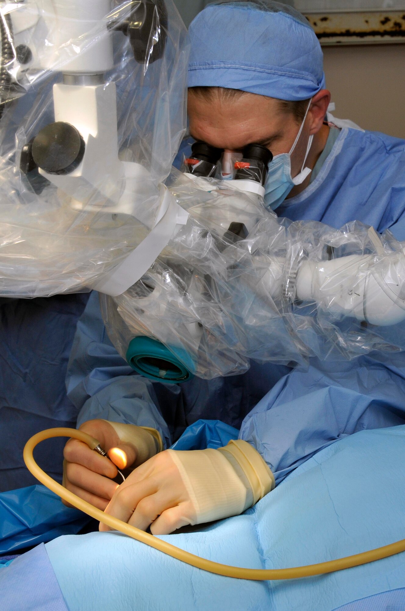 Lt. Col. Mark Packer, neuro-otologist from the 59th Medical Wing at Wilford Hall, Lackland Air Force Base, Texas, uses a microscope to perform surgery on a perforated eardrum Aug 6, 2009, at the Georgetown Public Hospital in Georgetown, Guyana. The team will perform approximately 32 surgeries and see more than 500 patients in eight days. (U.S. Air Force photo by Airman 1st Class Perry Aston) (Released)