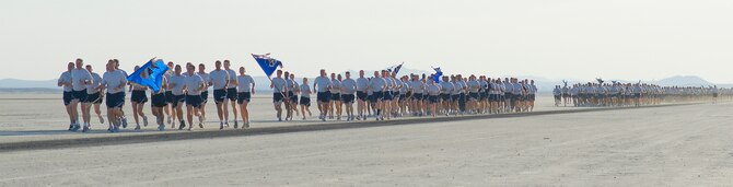 Maj. Gen. David Eichorn, Air Force Flight Test Center commander, leads the way on Roger's Dry Lakebed during the Installation Fitness Run Aug. 7.  The lakebed is made up of compacted clay covering approximately 44 square miles on Edwards with runways used for emergency aircraft landings.  The 2.8-mile run began and finished in front of building 1830.  After leaving the taxi-way, runners were completely surrounded by desert as they watched the base disappear in the distance.  There were no distinguishing landmarks on the dry lakebed; GPS devices were used to lay out the course.  (Air Force photo/Mike Cassidy)