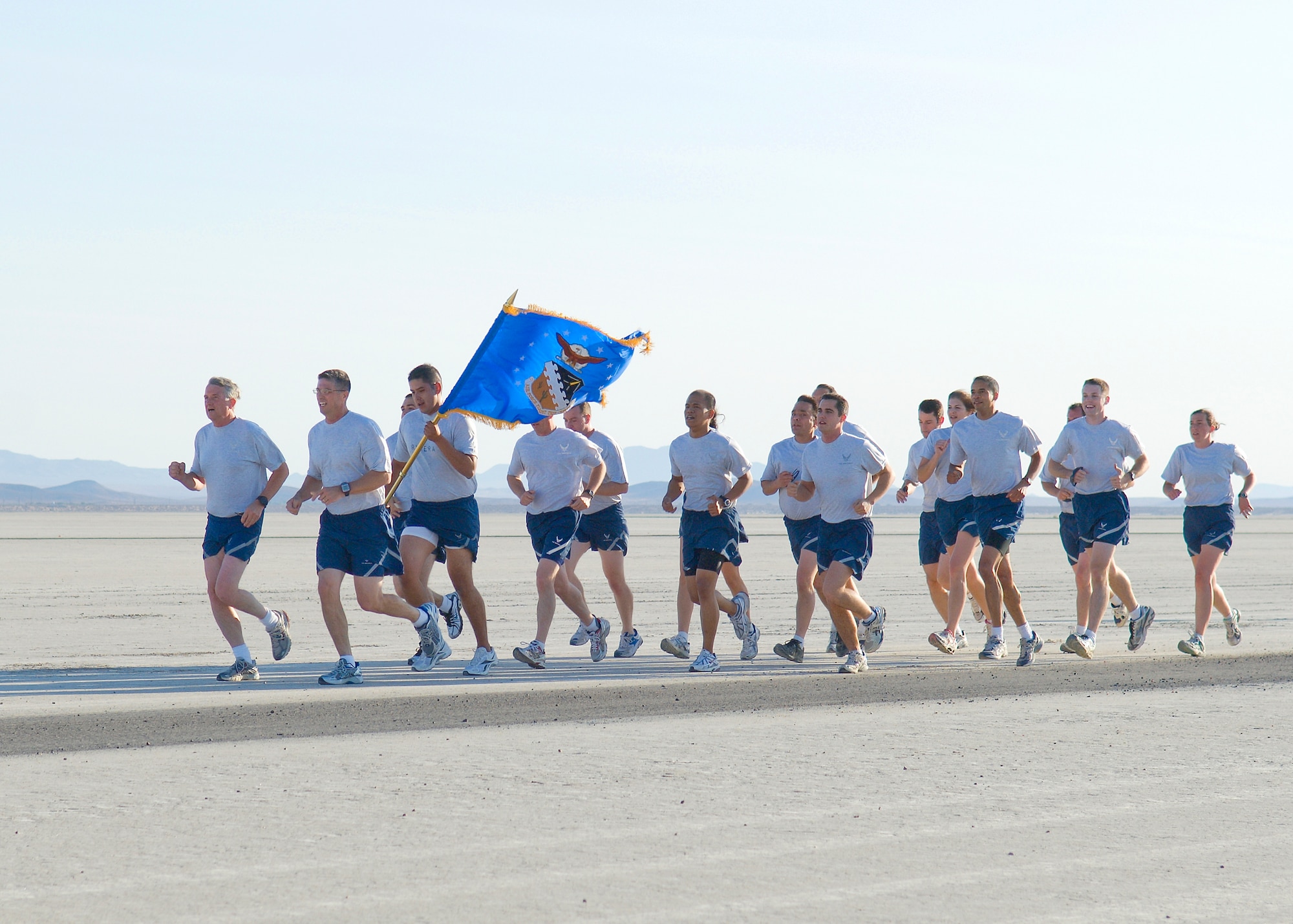 Maj. Gen. David Eichorn, Air Force Flight Test Center commander, and members of his staff, lead the way on Roger's Dry Lakebed during the Installation Fitness Run Aug. 7.  The lakebed is made up of compacted clay covering approximately 44 square miles on Edwards with runways used for aircraft emergency landings.  The 2.8-mile run began and finished in front of building 1830.  After leaving the taxi-way, runners were completely surrounded by desert as they watched the base disappear in the distance.  There were no distinguishing landmarks on the dry lakebed; GPS devices were used to lay out the course.  (Air Force photo/Mike Cassidy)