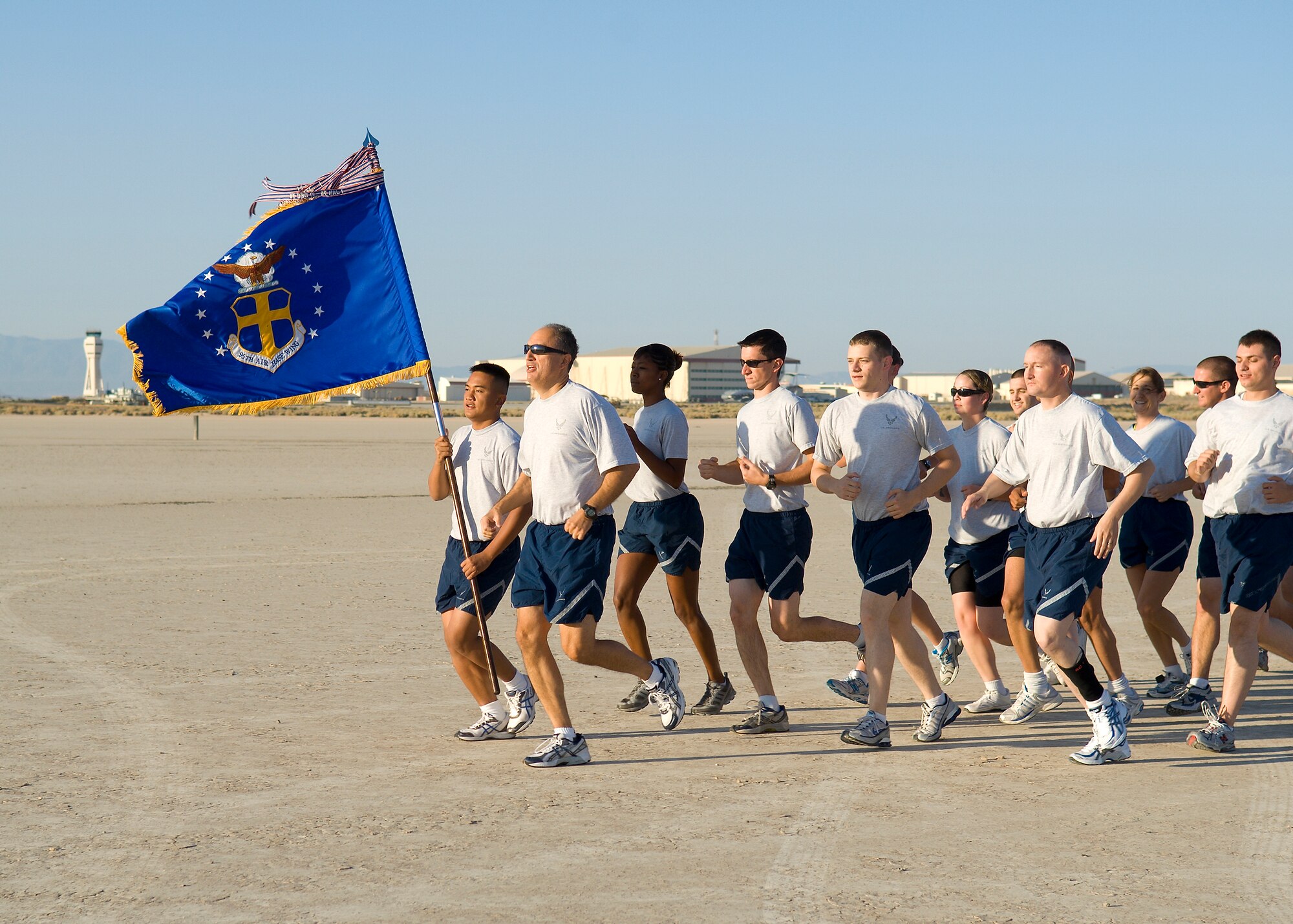 Col. Joseph Torres, 95th Air Base Wing vice commander, and members of the wing staff, run on Roger's Dry Lakebed during the Installation Fitness Run Aug. 7.  Roger’s Dry Lakebed is compacted clay covering approximately 44 square miles on Edwards with runways used for aircraft emergency landings.  The 2.8-mile run began and finished in front of building 1830.  After leaving the taxi-way, runners were completely surrounded by desert as they watched the base disappear in the distance.  There were no distinguishing landmarks on the dry lakebed; GPS devices were used to lay out the course.  (Air Force photo/Mike Cassidy)
