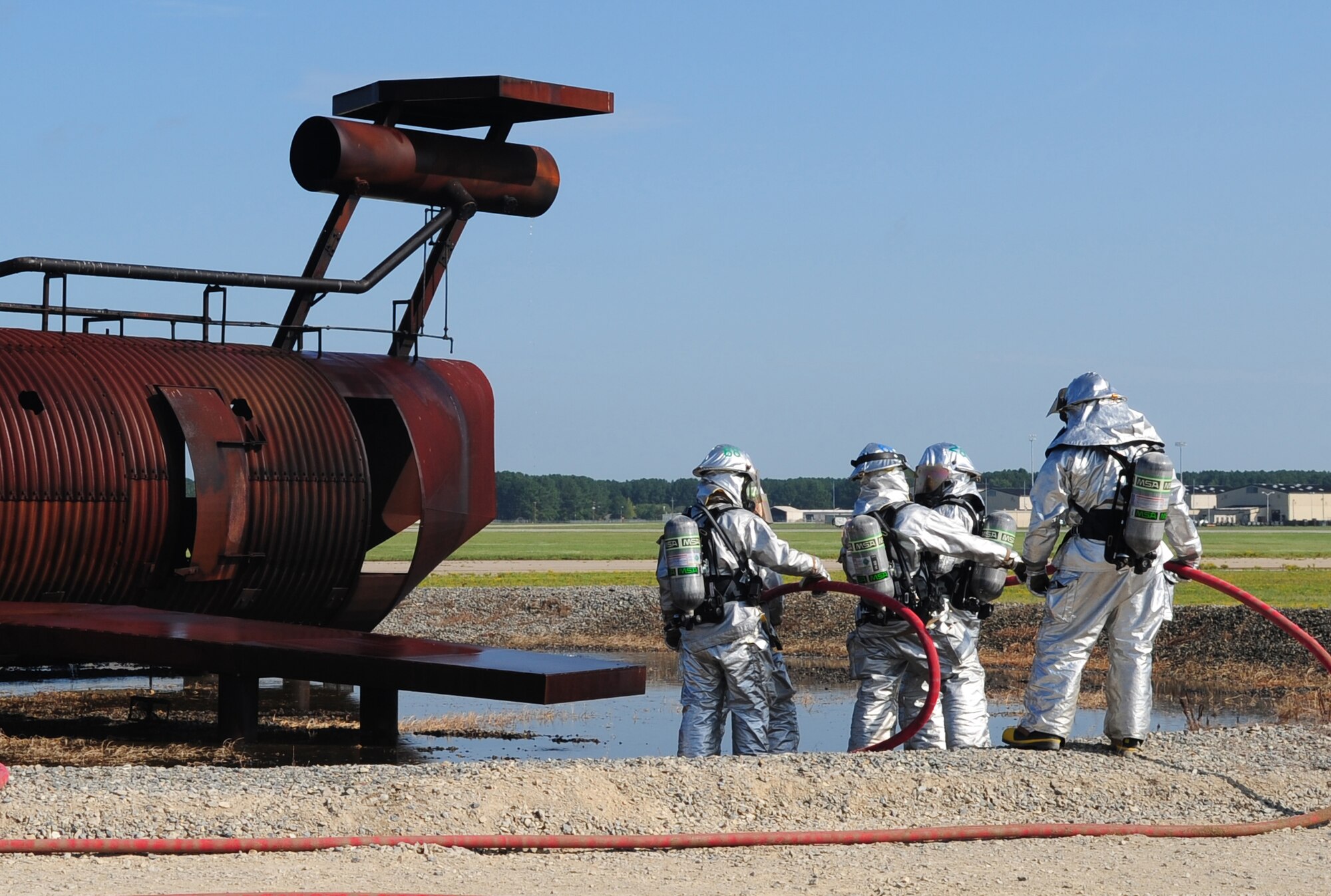 Airmen from the 4th Civil Engineer Squadron Fire Department prepare to enter a simulated downed aircraft during an exercise at Seymour Johnson Air Force Base, N.C., July 31, 2009. Firefighters enter in pairs to ensure they and their wingman make it back out together. (U.S. Air Force photo by Airman 1st Class Rae Perry)