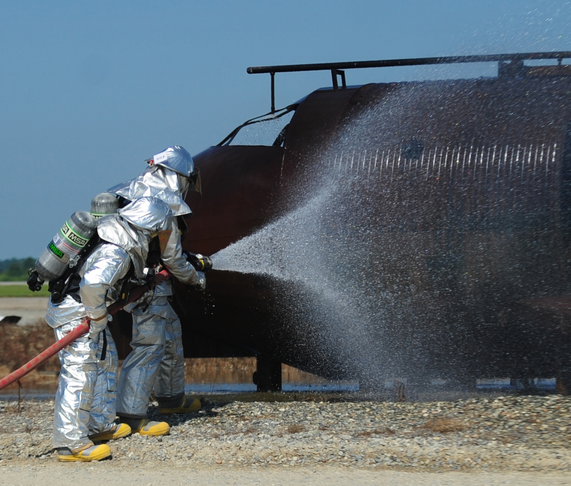 Airmen from the 4th Civil Engineer Squadron Fire Department release air pressure from a hose during a live-fire exercise at Seymour Johnson Air Force Base, N.C., July 31, 2009. The fire hoses are built to withstand 150 pounds of water per square inch and pump out approximately 100 gallons of water a minute. (U.S. Air Force photo by Airman 1st Class Rae Perry)
