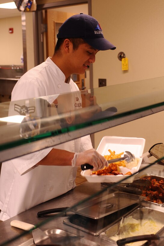Airman 1st Class Roldan Corcuera, 28th Force Support Squadron food services journeyman, places mashed potatoes in an Airman’s to-go box at the flight kitchen here, August 11. The flight kitchen provides meals for Ellsworth personnel working on the flightline. (U.S. Air Force photo/Senior Airman Kasey Zickmund)