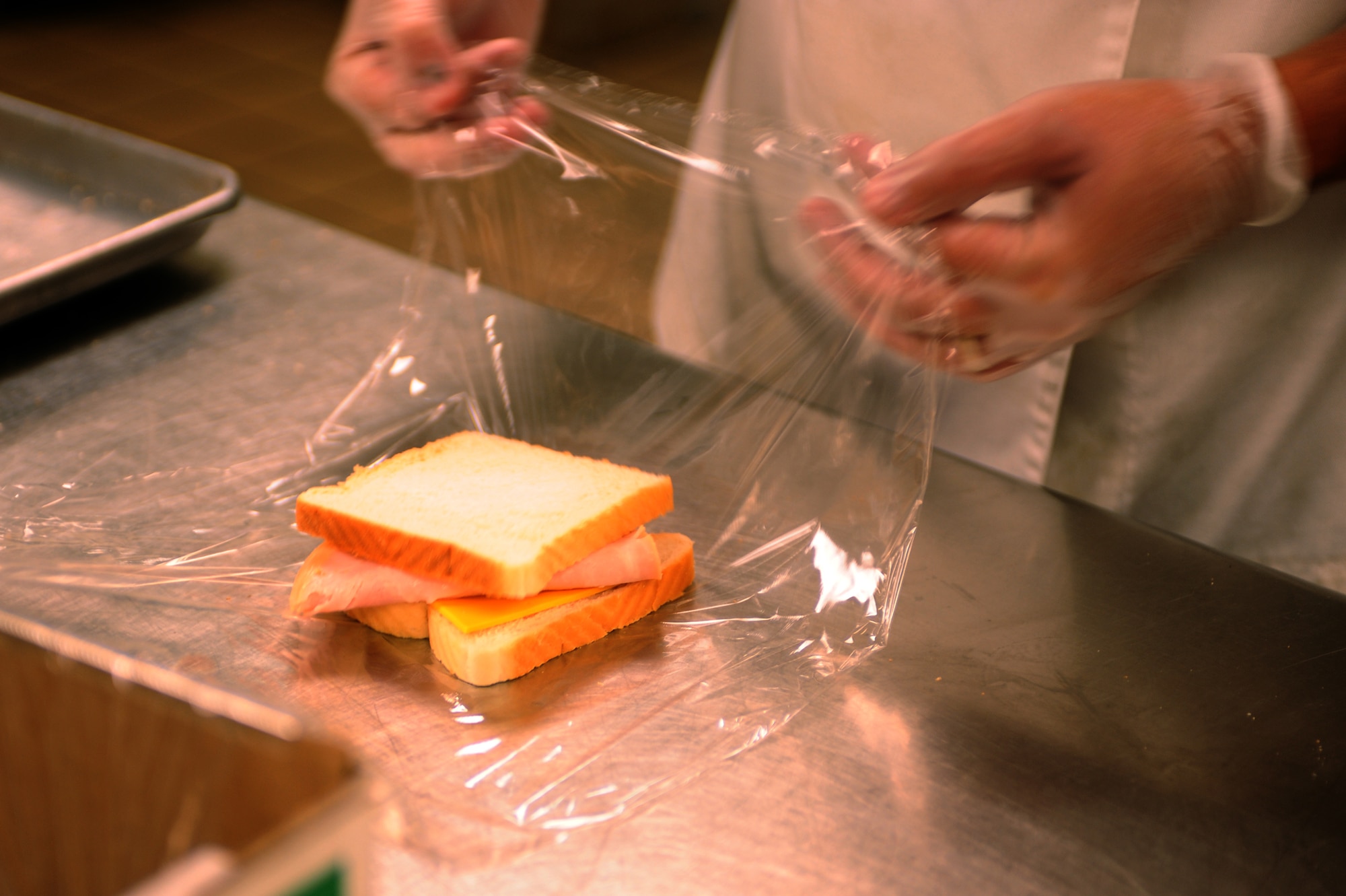 Senior Airman Billy Janca, 28th Force Support Squadron food services journeyman, wraps a turkey sandwich at the flight kitchen here, August 11. This action ensures the freshness of the sandwich. (U.S. Air Force photo/Senior Airman Kasey Zickmund)