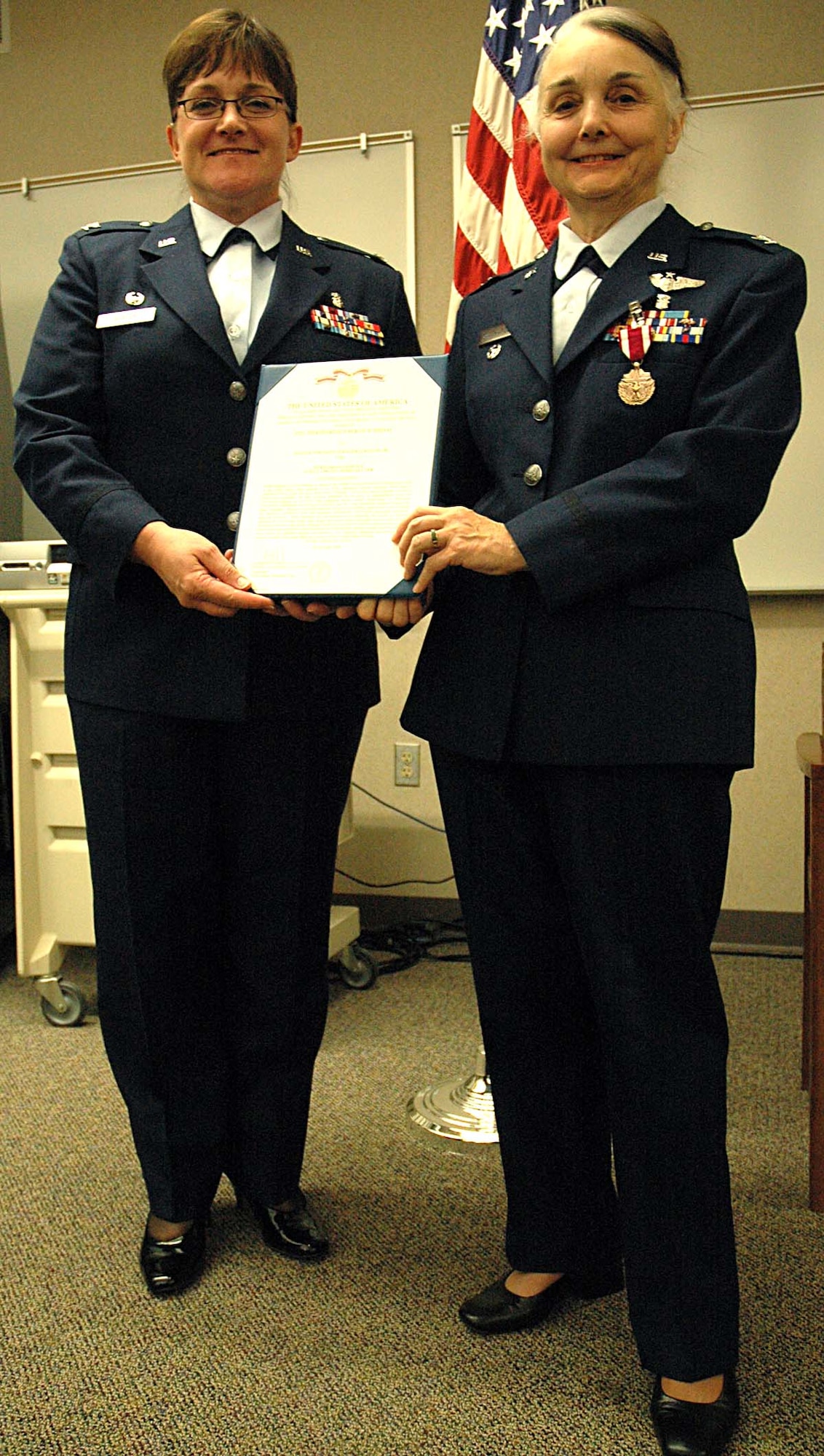 Col. Karen Winter, left, presents Col. Sandra Smith-Poling,the Meritorious Service Medal at Colonel Smith-Poling's retirement ceremony.  Colonel Smith-Poling served more than 20 years in the Air Force.  Both colonels are with the 446th Aeromedical Staging Squadron, a Reserve unit at McChord Air Force Base, Wash.  (Air Force photo/Senior Airman Patrick Cabellon)