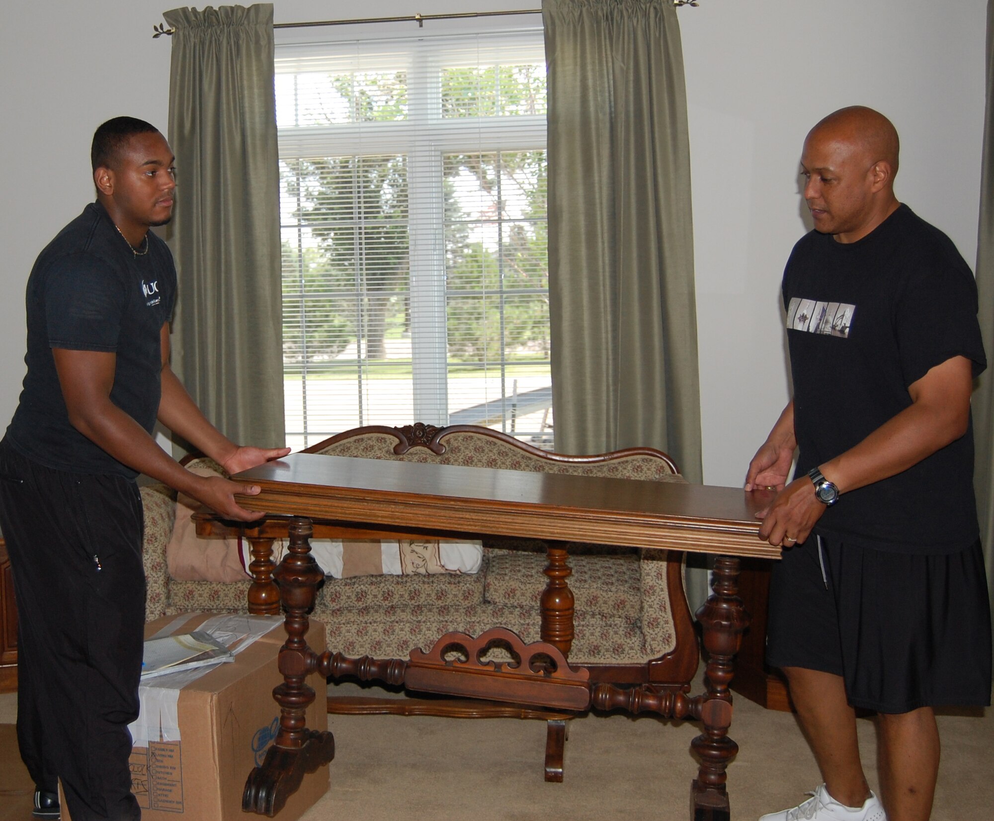 Col. Anthony Cotton, 341st Missile Wing vice commander, (right) gets some help from his son, Russel, moving household goods into their on-base house Aug. 10. Russel is here visiting for a few weeks before returning to college at the University of Central Florida for his senior year. (U.S. Air Force photo/Valerie Mullett) 