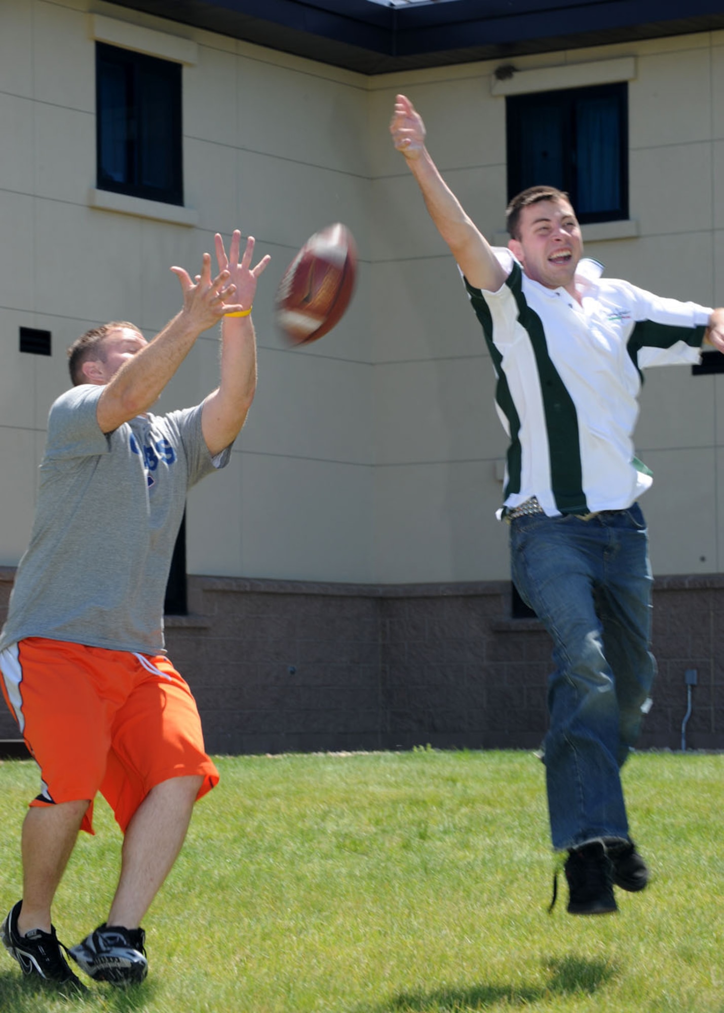 Senior Airmen Micheal Brunn and Ethan Brown, 566 Intelligence Squadron, catch a pass during the Airman barbecue. Pick-up games of football, volleyball and other sports made sure Airmen living in Patriot Hall had fun during the base-wide power outage. (U.S Air Force photo by Airman 1st Class Paul Labbe)