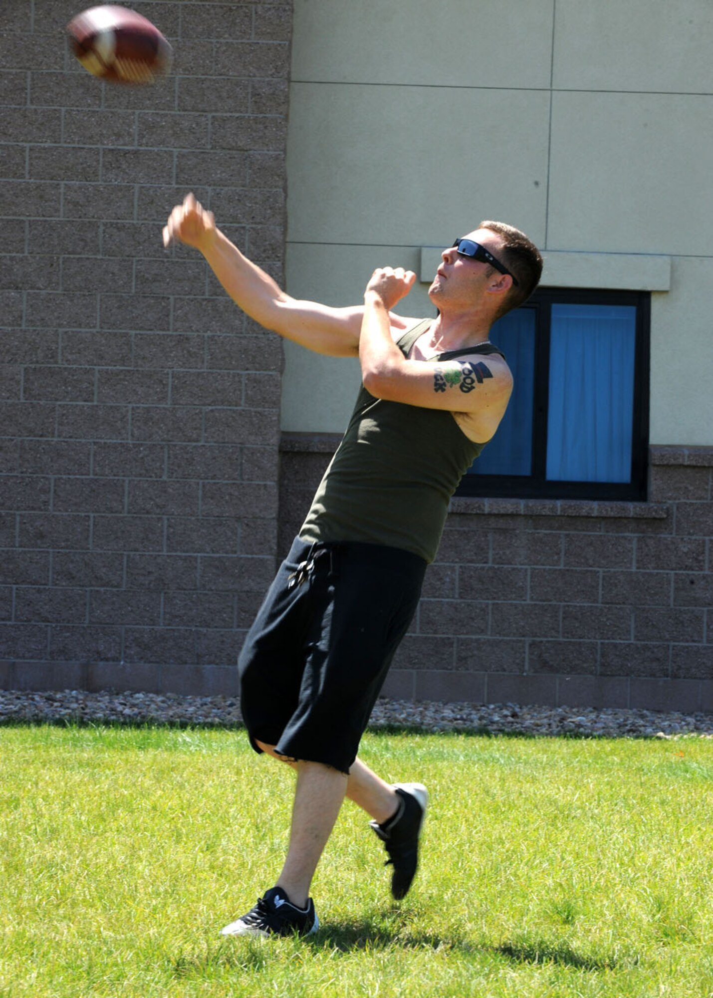 Airman 1st Class Jeremy Pryor, 566th Intelligence Squadron, throws a long pass during the Airman barbecue. Pick-up games of football, volleyball and other sports made sure Airmen living in Patriot Hall had fun during the base-wide power outage. (U.S. Air Force photo by Airman 1st Class Paul Labbe)