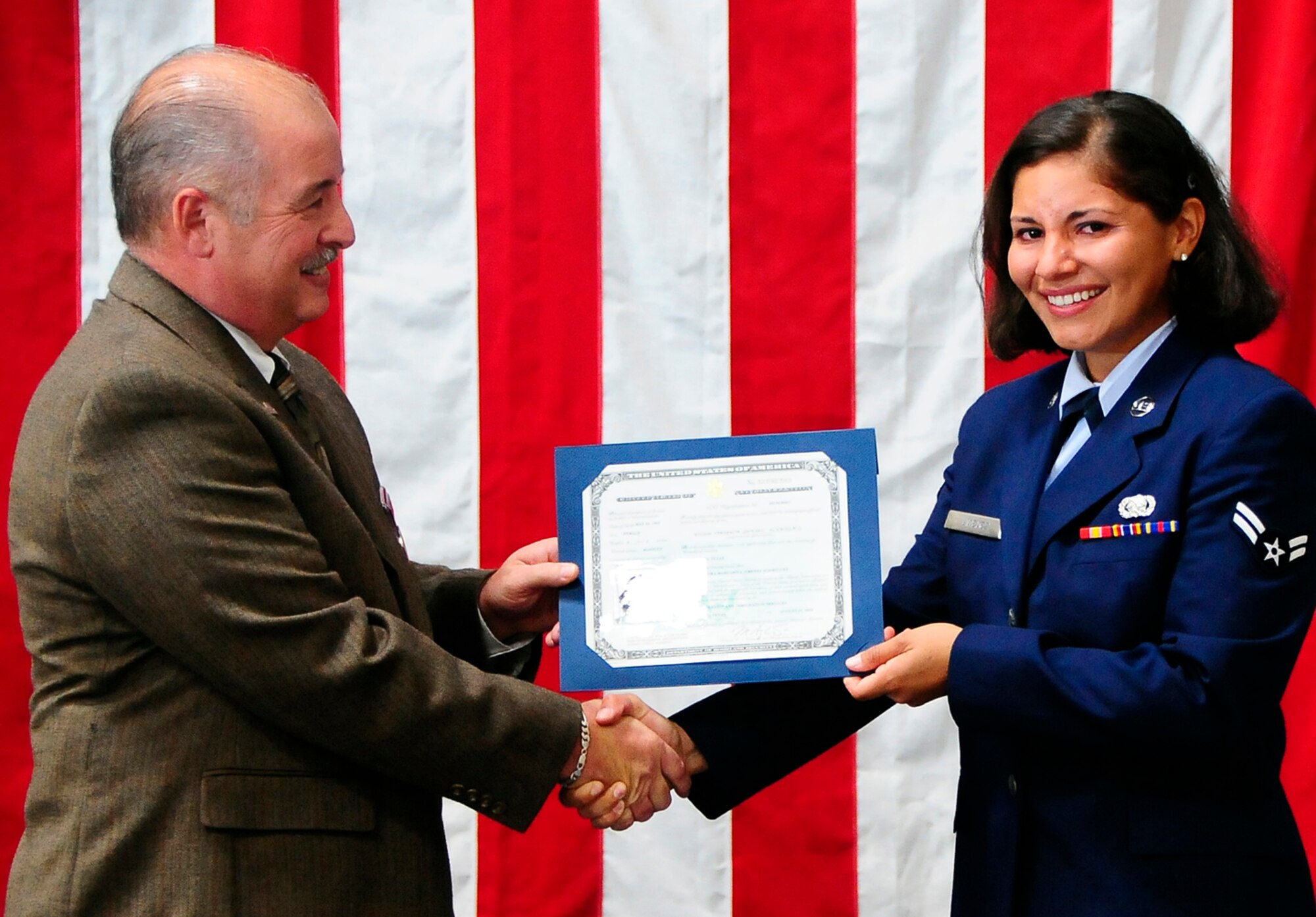 HOLLOMAN AIR FORCE BASE, N.M. -- Airman 1st Class Indira Jimenez, 49th Materiel Maintenance Group, receives her citizenship from James Spurling, supervisor of the El Paso Field Office, Department of Homeland Security, during her naturalization ceremony here Aug. 7. Airman Jimenez is a native of Bogota, Columbia. (U.S. Air Force photo by Tech. Sgt. Chris Flahive)