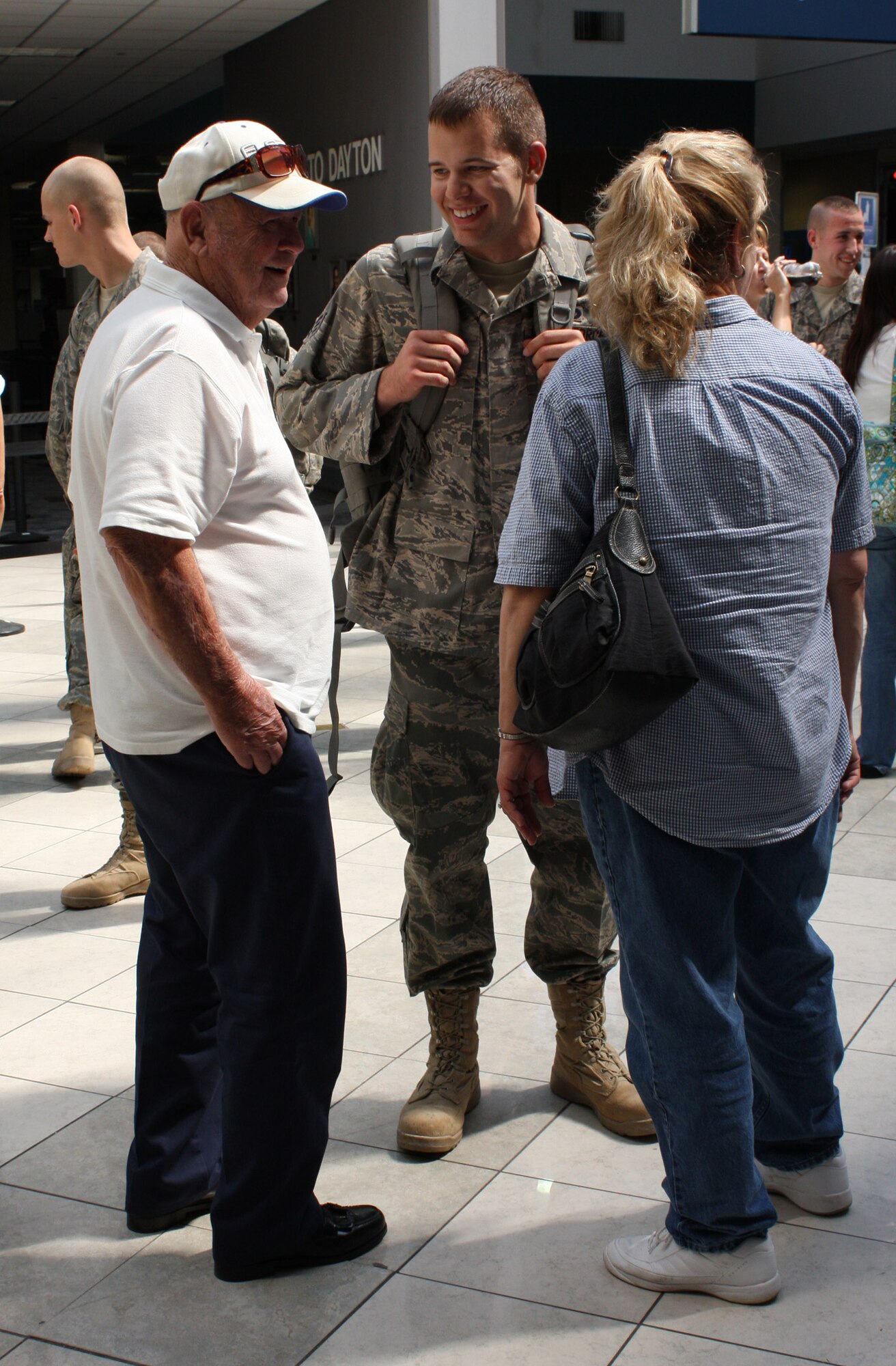 WRIGHT-PATTERSON AIR FORCE BASE, Ohio – Senior Airman Jason Gardiner, 445th Security Forces Squadron, talks with his family while waiting for his luggage after returning from a 6-month deployment in Southwest Asia. Airman Gardiner 11 reservists from the 445th Security Forces Squadron were greeted by family and friends when they arrived at the Dayton International Airport Aug. 6. (U. S. Air Force photo/Stacy Vaughn)
